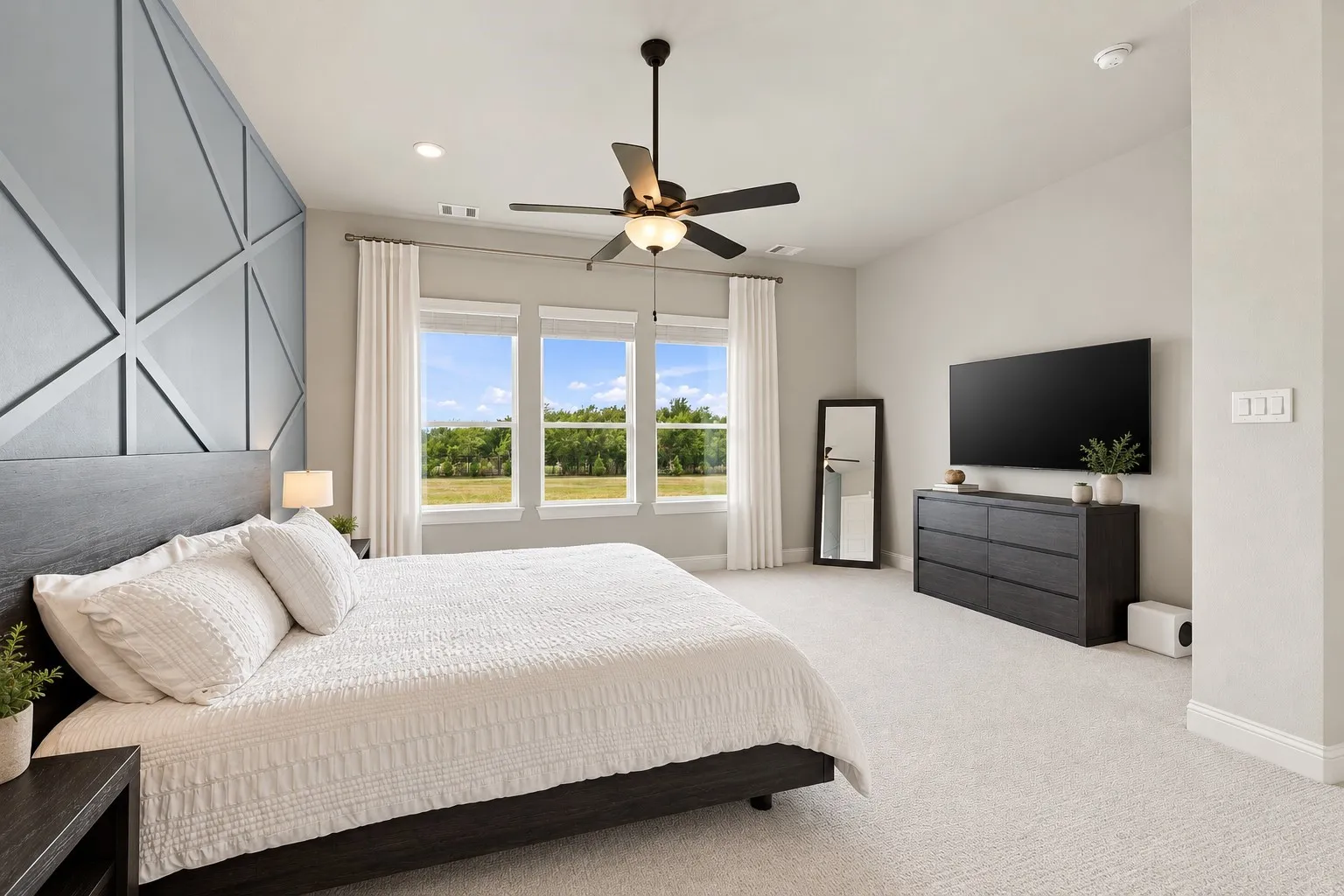 Vaulted ceiling with geometric accent wall, recessed lighting, and a ceiling fan