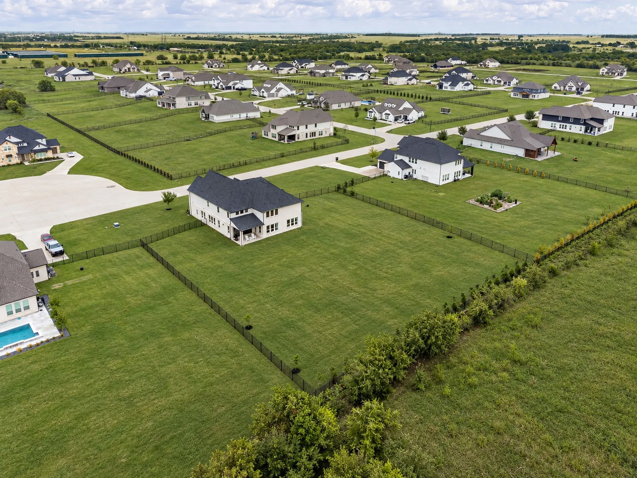 Expansive green spaces with individual perimeter fencing define this residential development