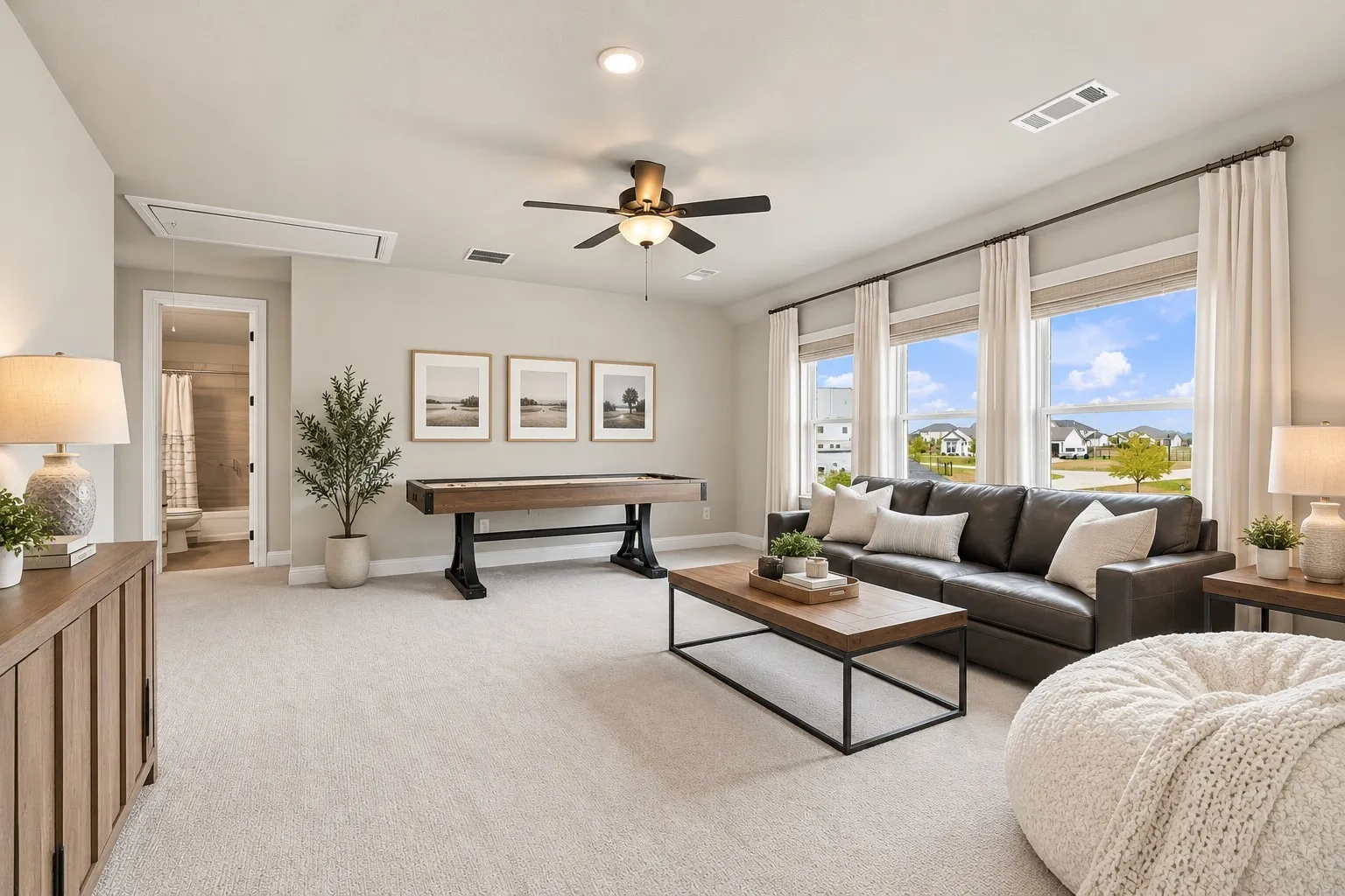 Carpeted living area with multiple large windows, recessed lighting, and a ceiling fan