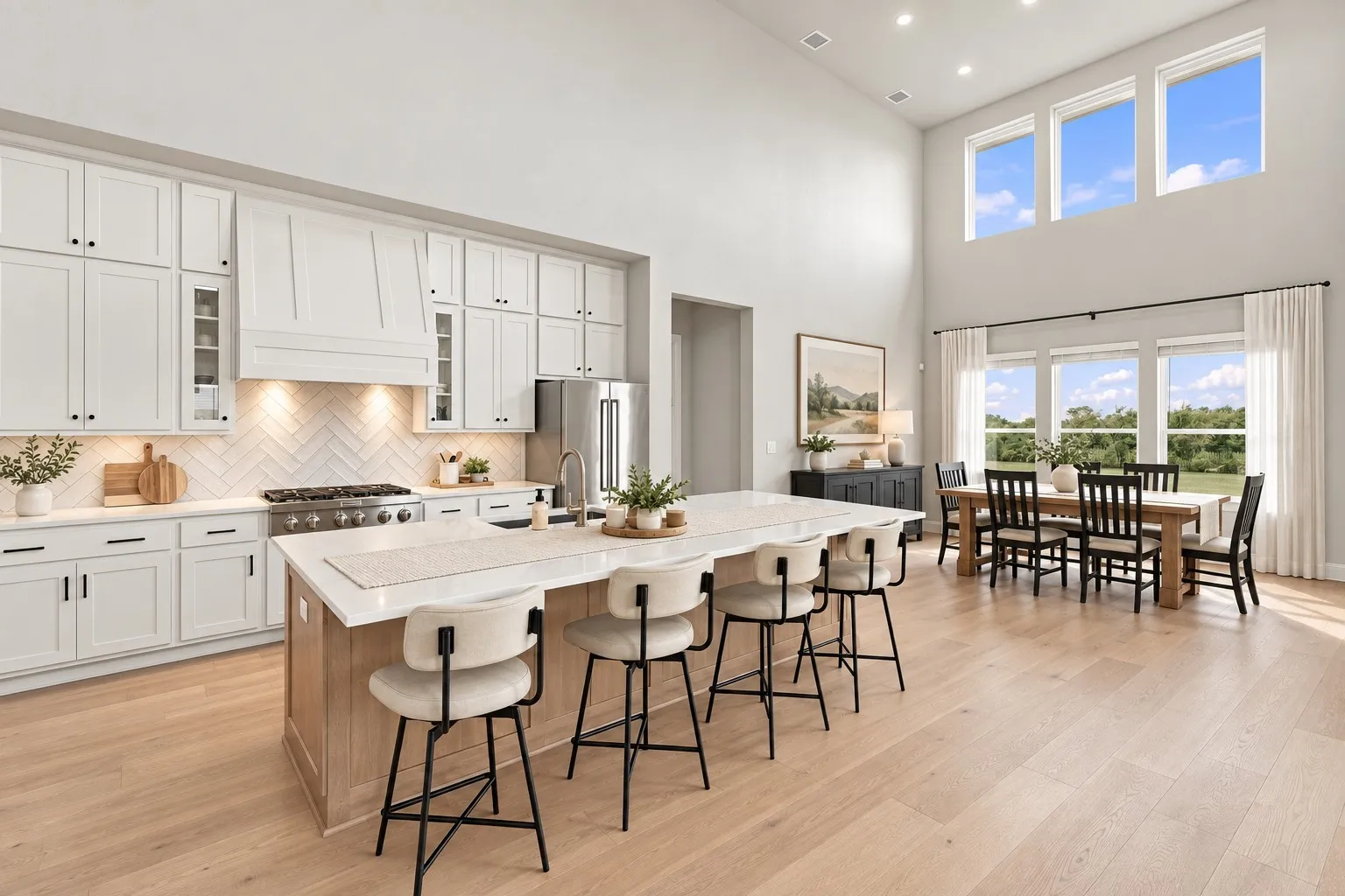 Spacious kitchen with a large central island, white shaker cabinetry, stainless steel appliances, and wood-finish flooring