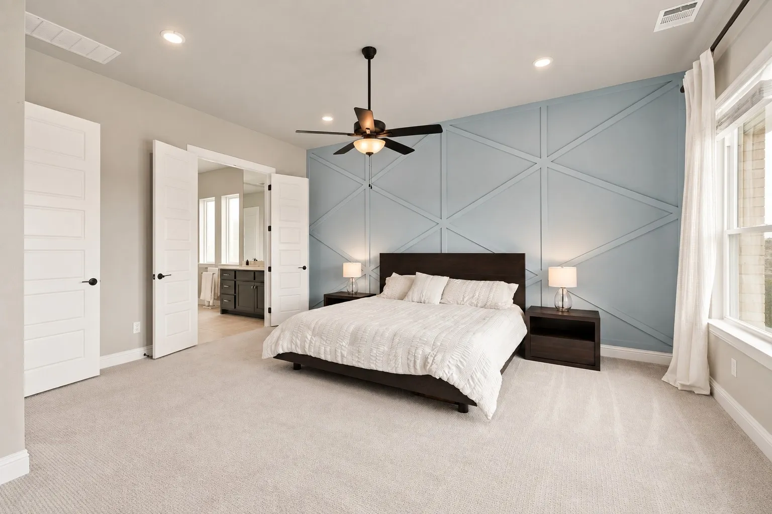 Wall with geometric accent molding, ceiling fan with integrated lighting, recessed ceiling lighting, light-toned carpeting, and white interior doors