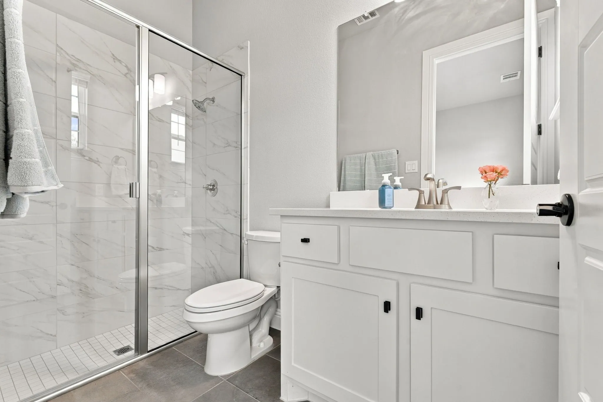 White shaker-style vanity with a light-toned countertop, under-mount sink, and brushed nickel faucet