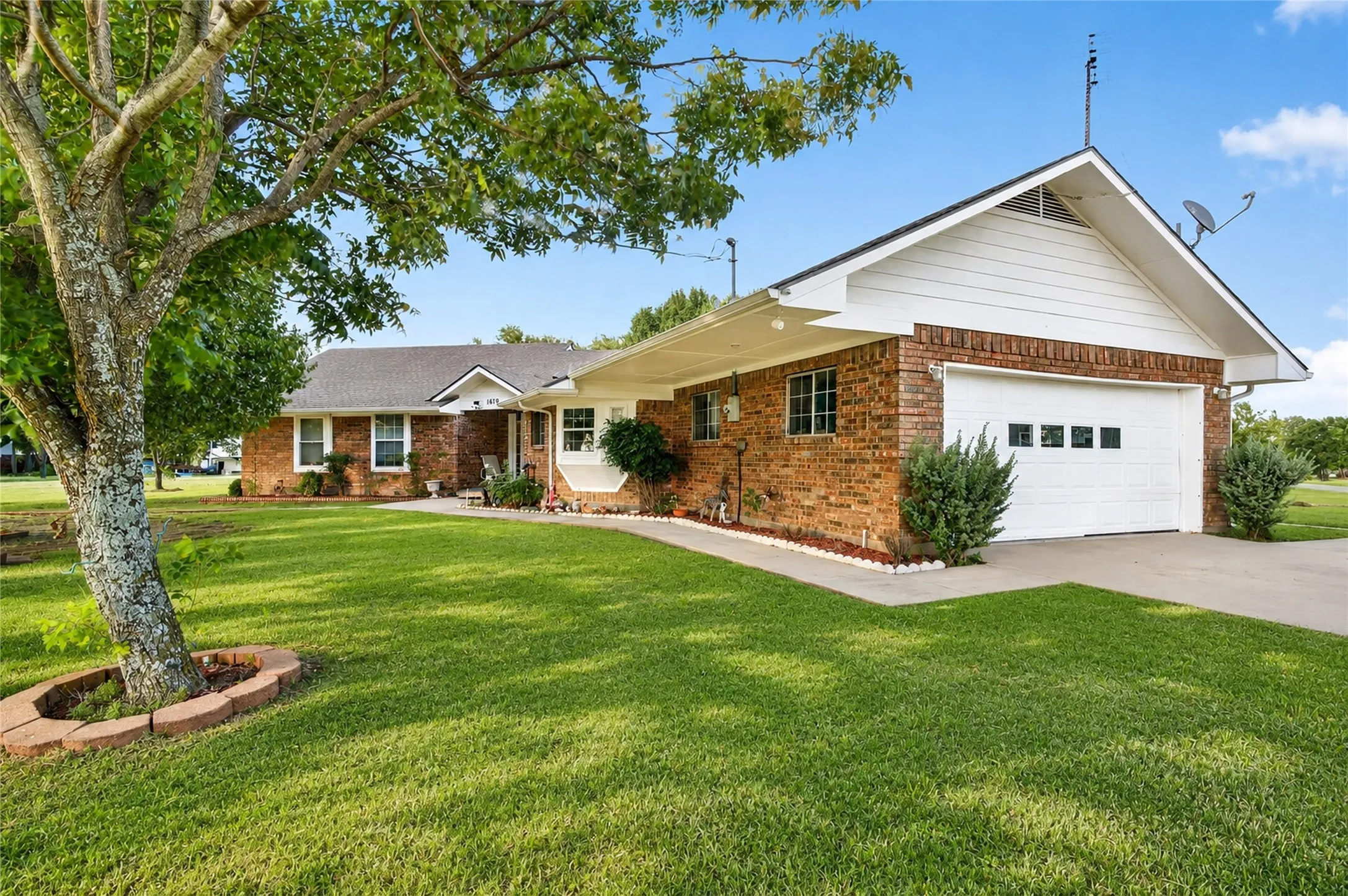 Brick exterior with white siding accents and a white garage door
