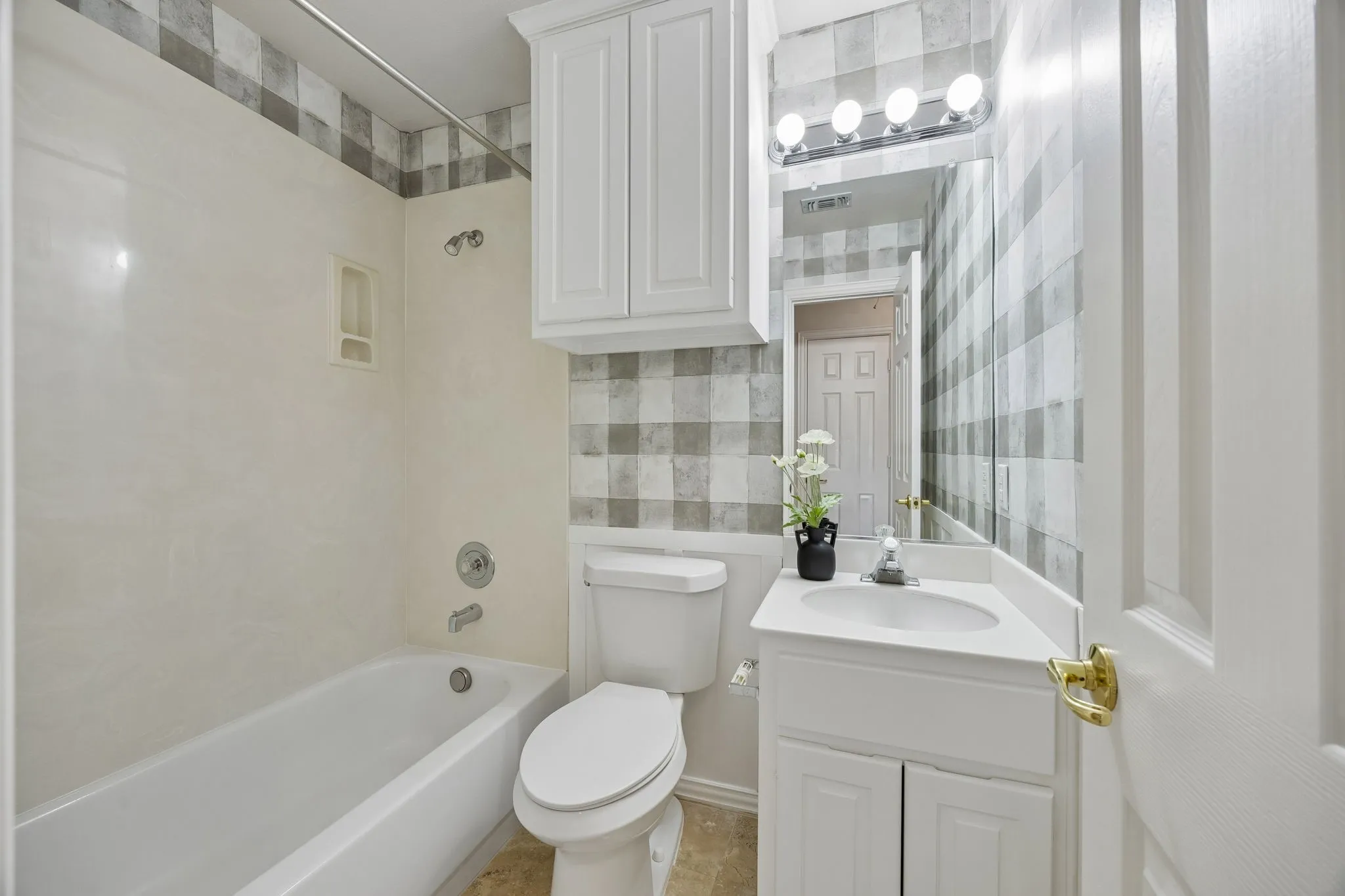 Bathroom found in the second primary has storage cabinet and tub with shower.