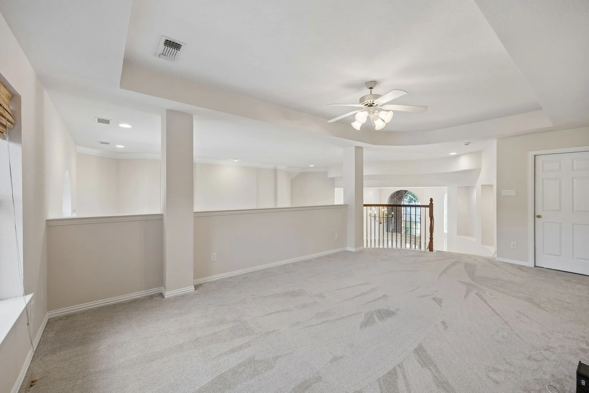 View of the game room highlighting the open feel of the room. Tray ceiling adds to the spaciousness. The doorway in the background leads to floored attic space that has the potential to be converted to a media room.