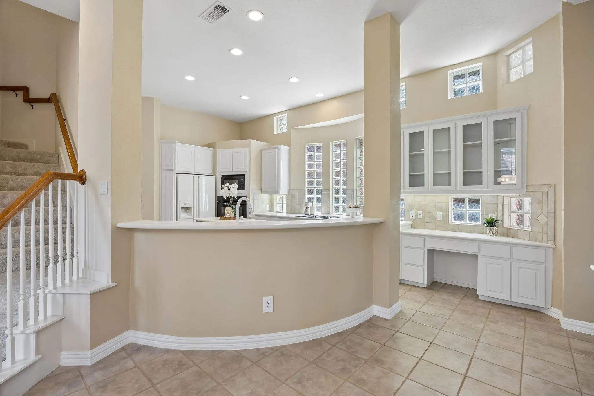 As the kitchen flows into the casual dining area you will find a built in desk and additional glass front cabinets. The house boasts a second staircase!