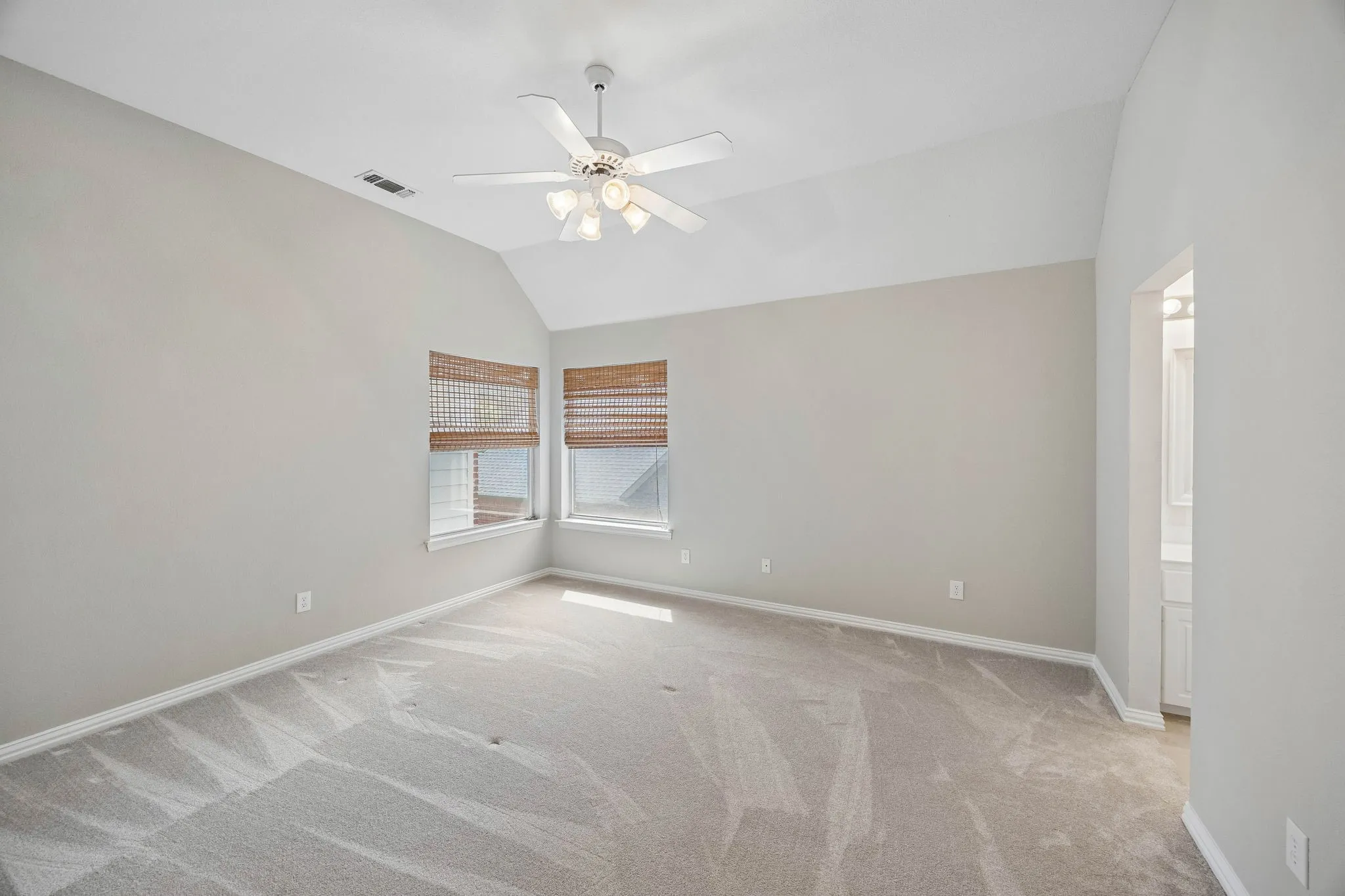 Split secondary bedroom has carpet, ceiling fan, walk-in closet and en suite jack and jill bathroom.