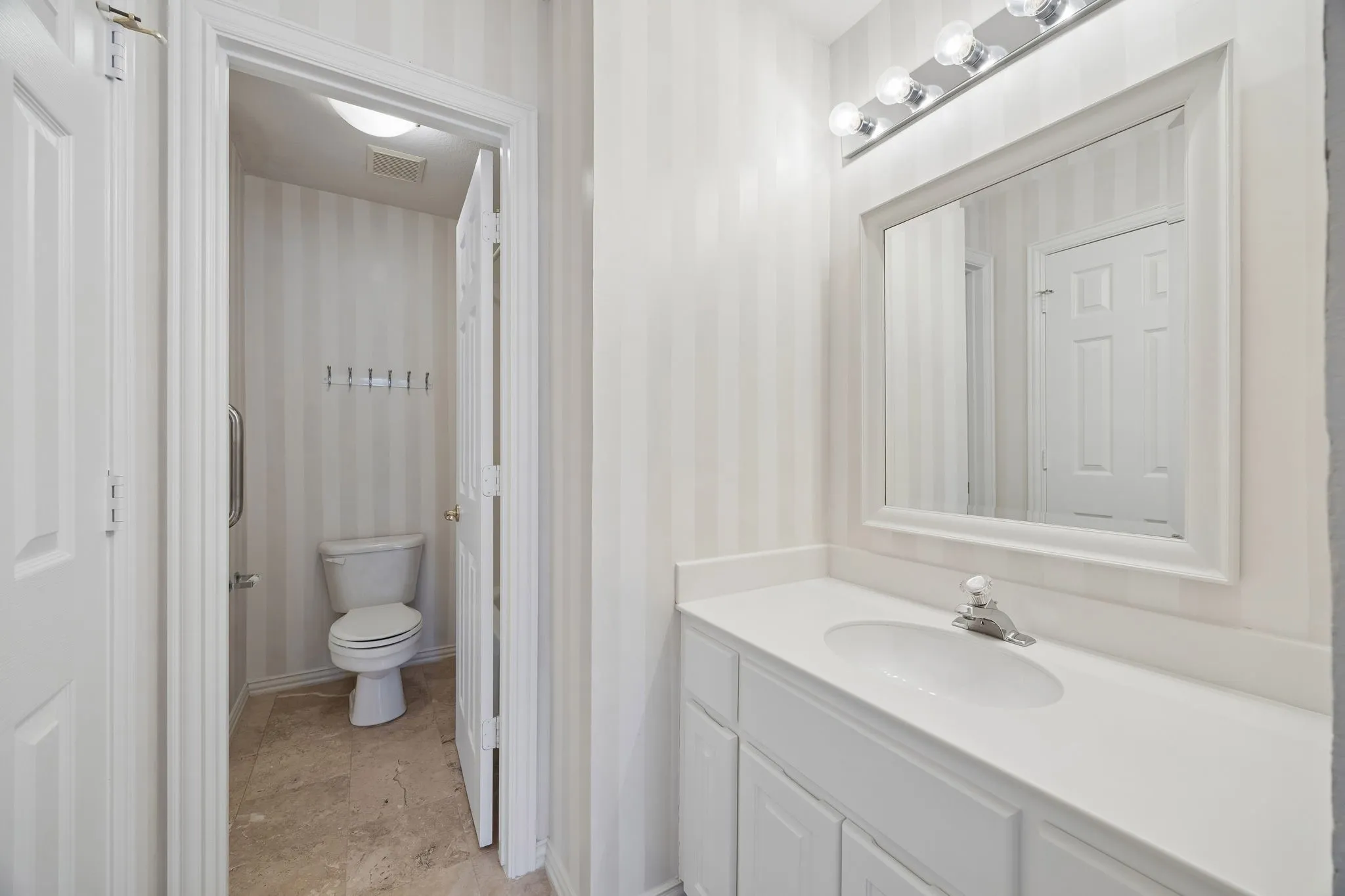 Vanity area of the jack and jill bathroom looking through to the shared watercloset with tub with shower.