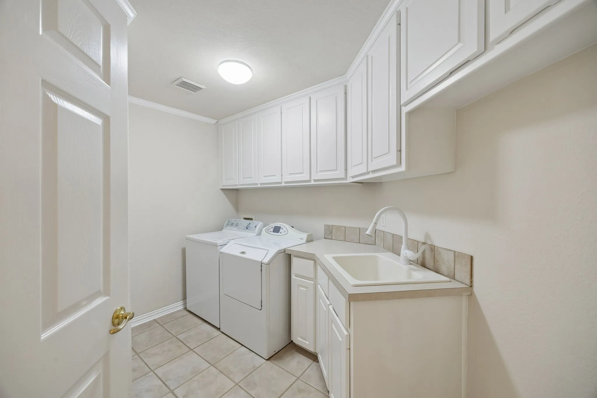 The spacious utility room has room for a second refrigerator as well as providing great storage, a utility sink and counterspace.