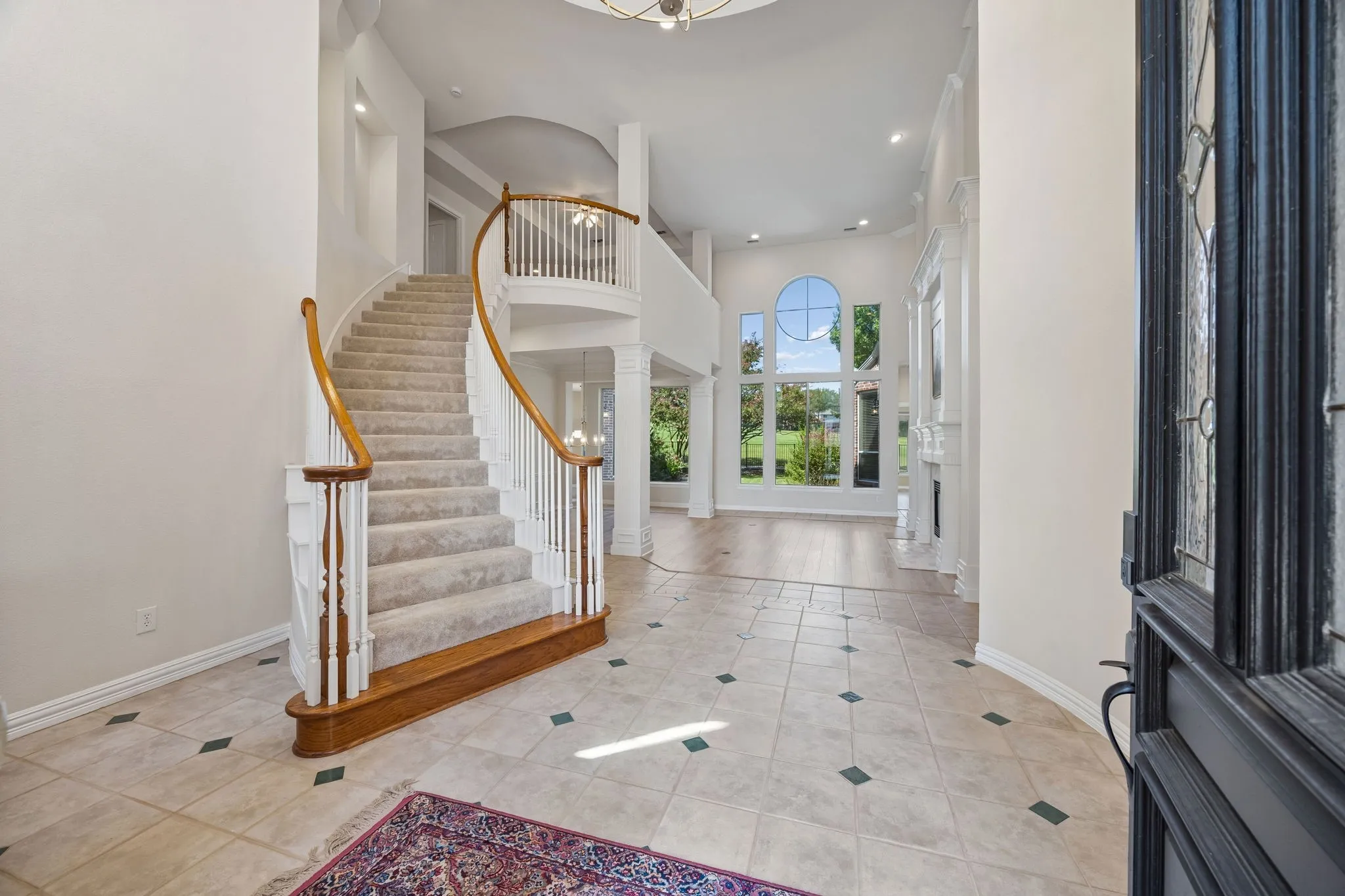 The grand entry is open to the second floor and offers a sweeping staircase to the gameroom as well as gorgeous views of the lush backyard and golf course beyond.