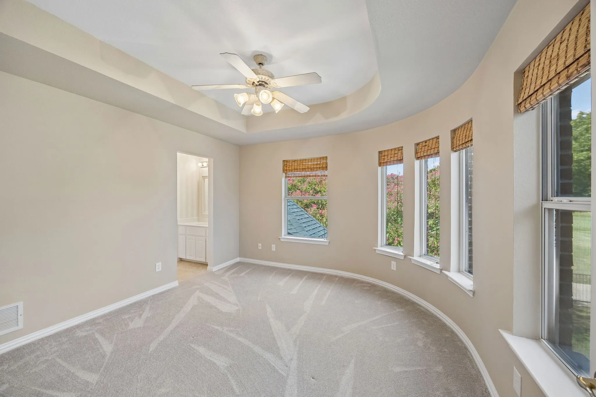 Split secondary bedroom enjoys the graceful curved lines of the home and has carpet, ceiling fan, walk-in closet and en suite jack and jill bathroom.