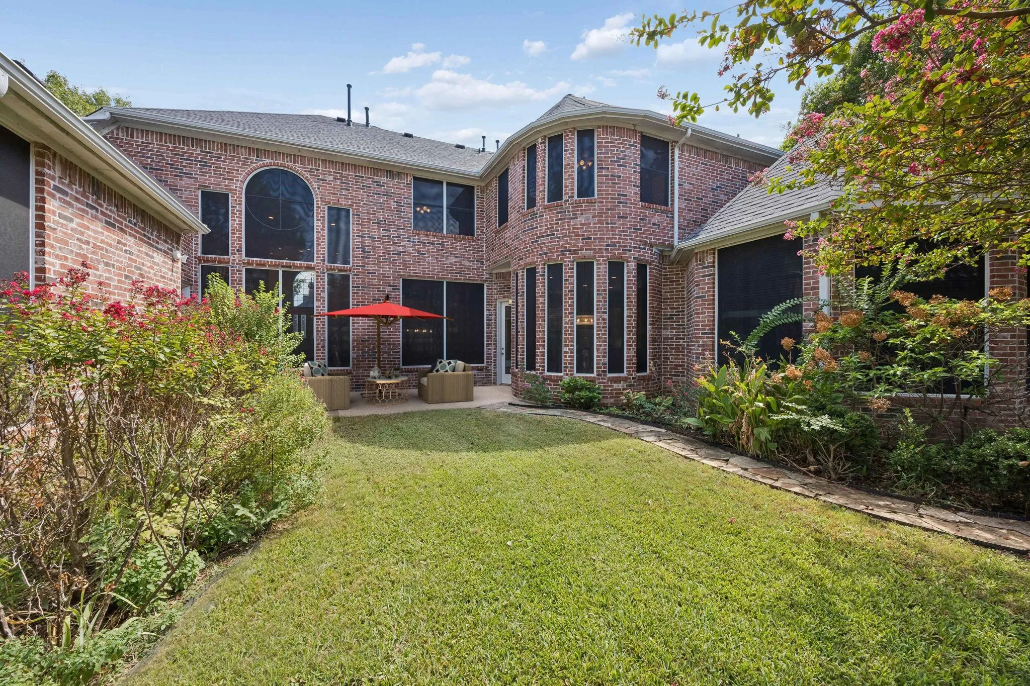 Looking toward the back of the home you find a large patio area and landscaped beds.