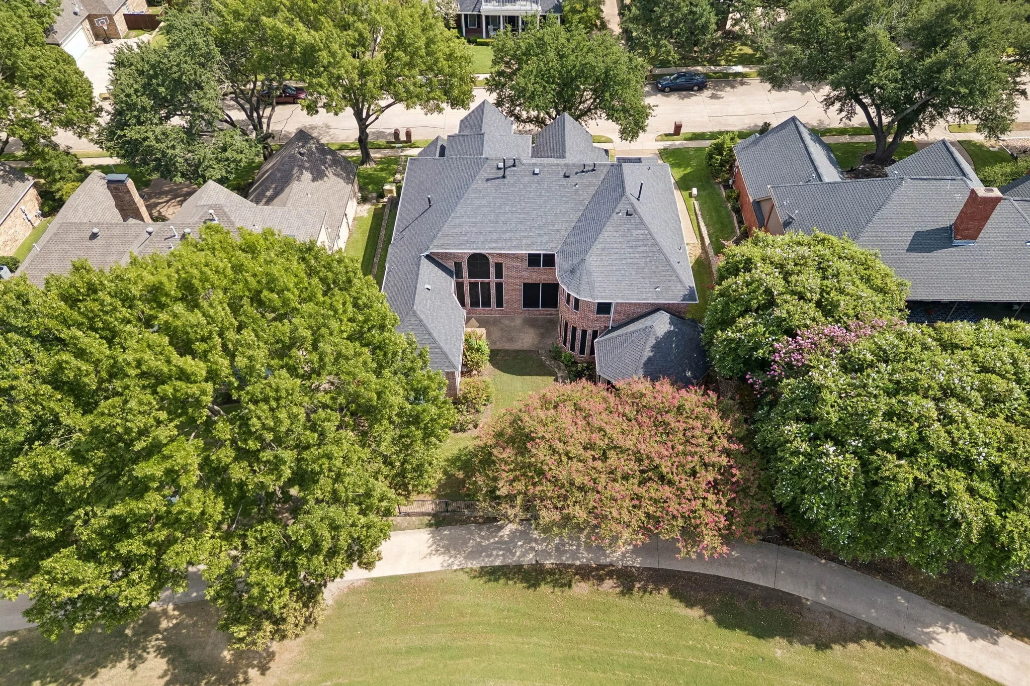 Aerial view looking toward the back of the home and highlighting the walking path behind the home.
