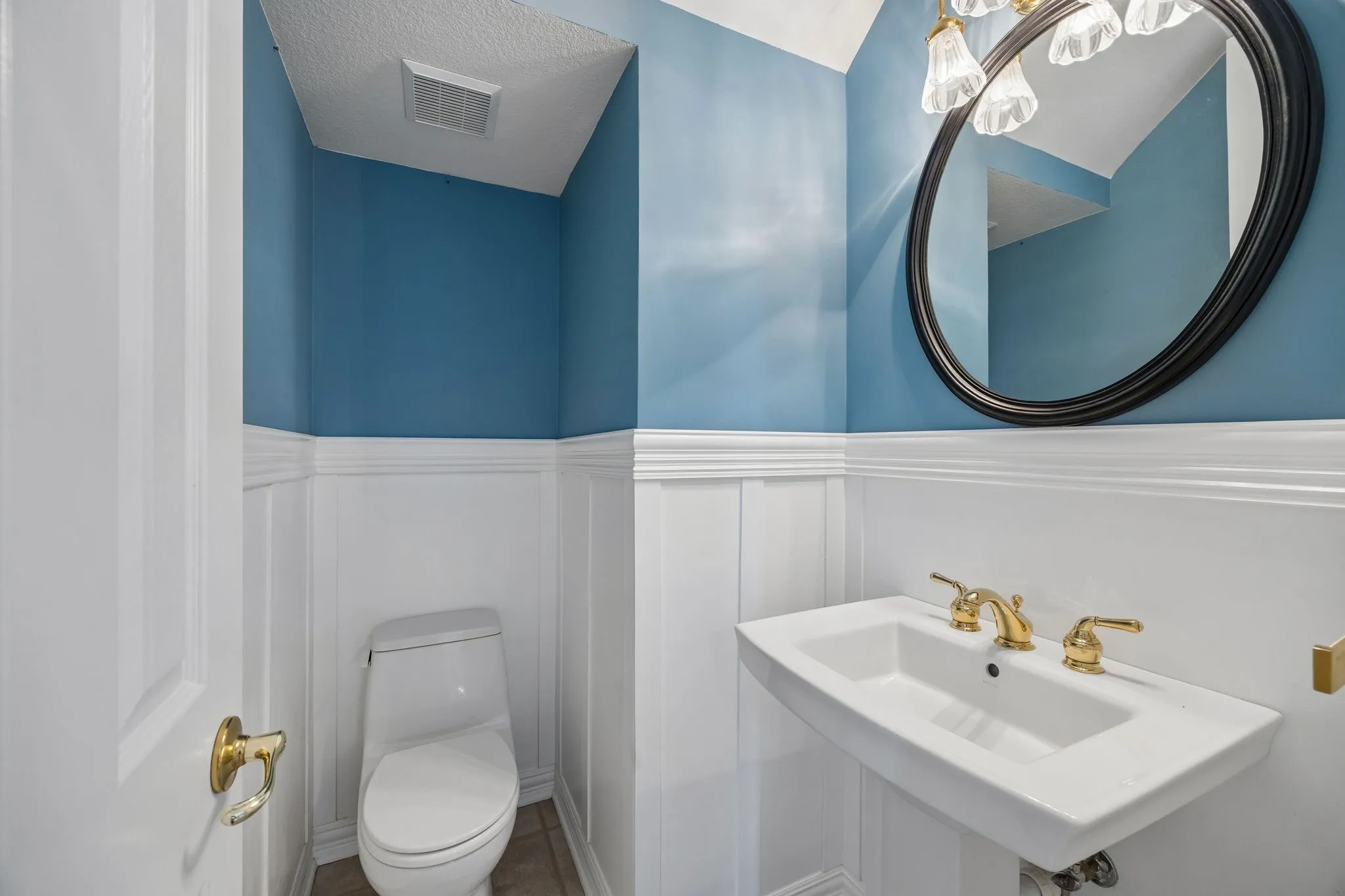 The powder room is conveniently located between the formals and the casual spaces in the home.