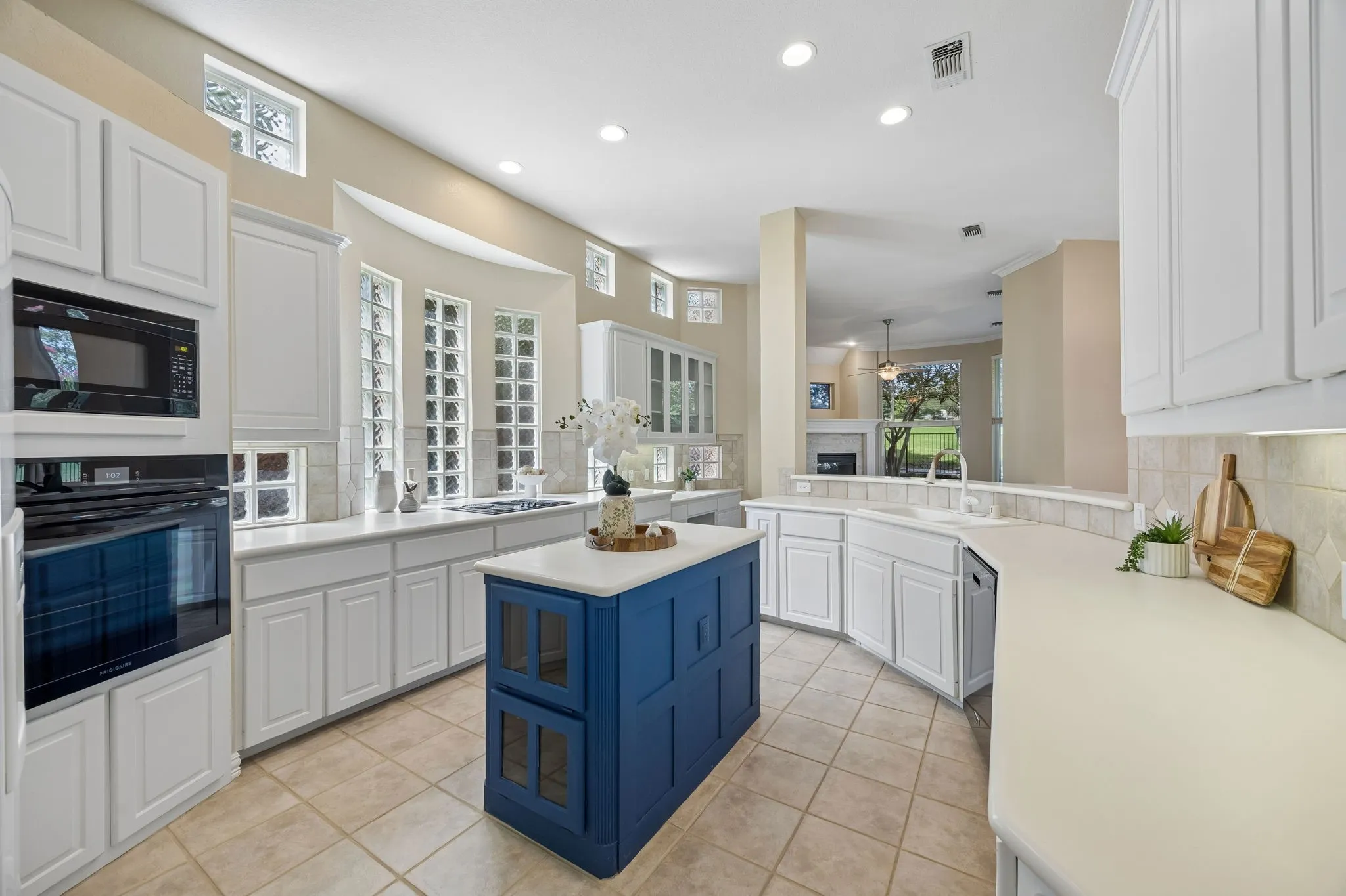 The kitchen is quite large and provides ample storage and counter space. The center island has additional storage, bins for vegetables and shelves on the opposite side. The kitchen has corian countertops, 42in upper cabinets and black appliances complete.