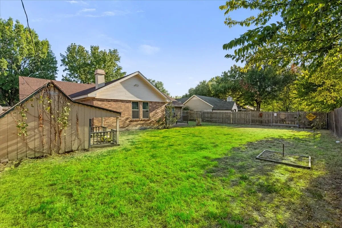 Expansive lawn space featuring a wood fence perimeter