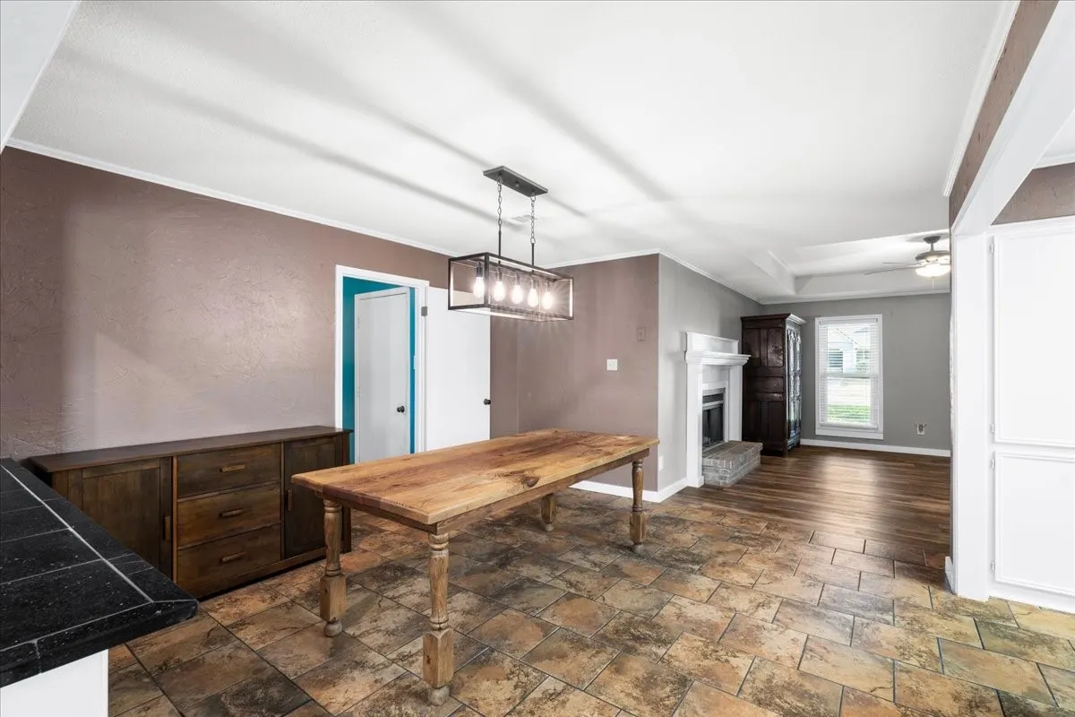 Tile flooring and wood-finish flooring complement the white trim and tray ceiling