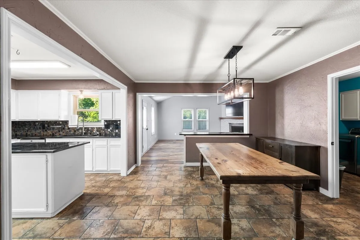 Kitchen featuring white cabinetry, dark countertops, and a tiled backsplash