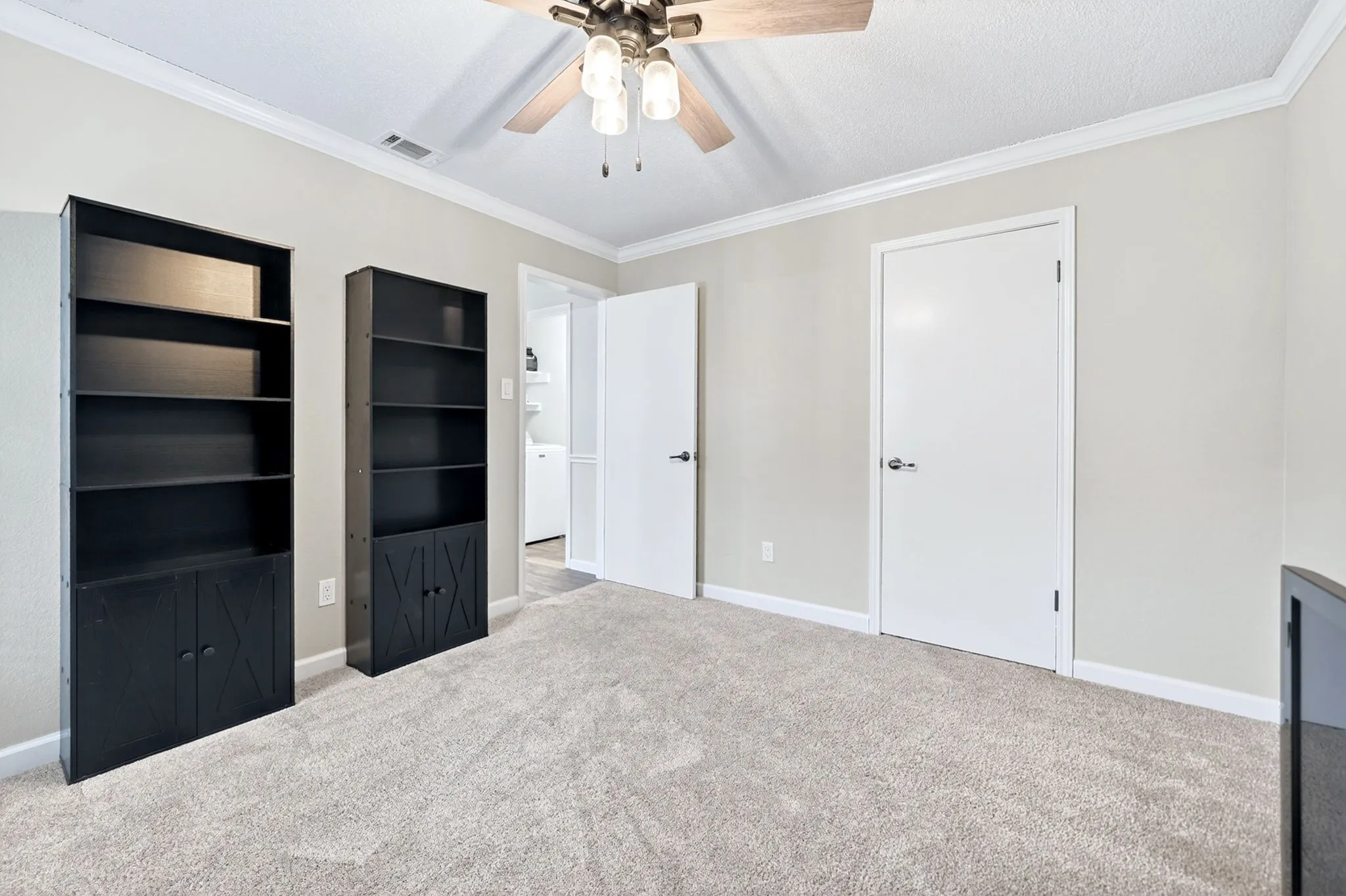 Neutral tone walls with crown molding, ceiling fan, and carpeted flooring