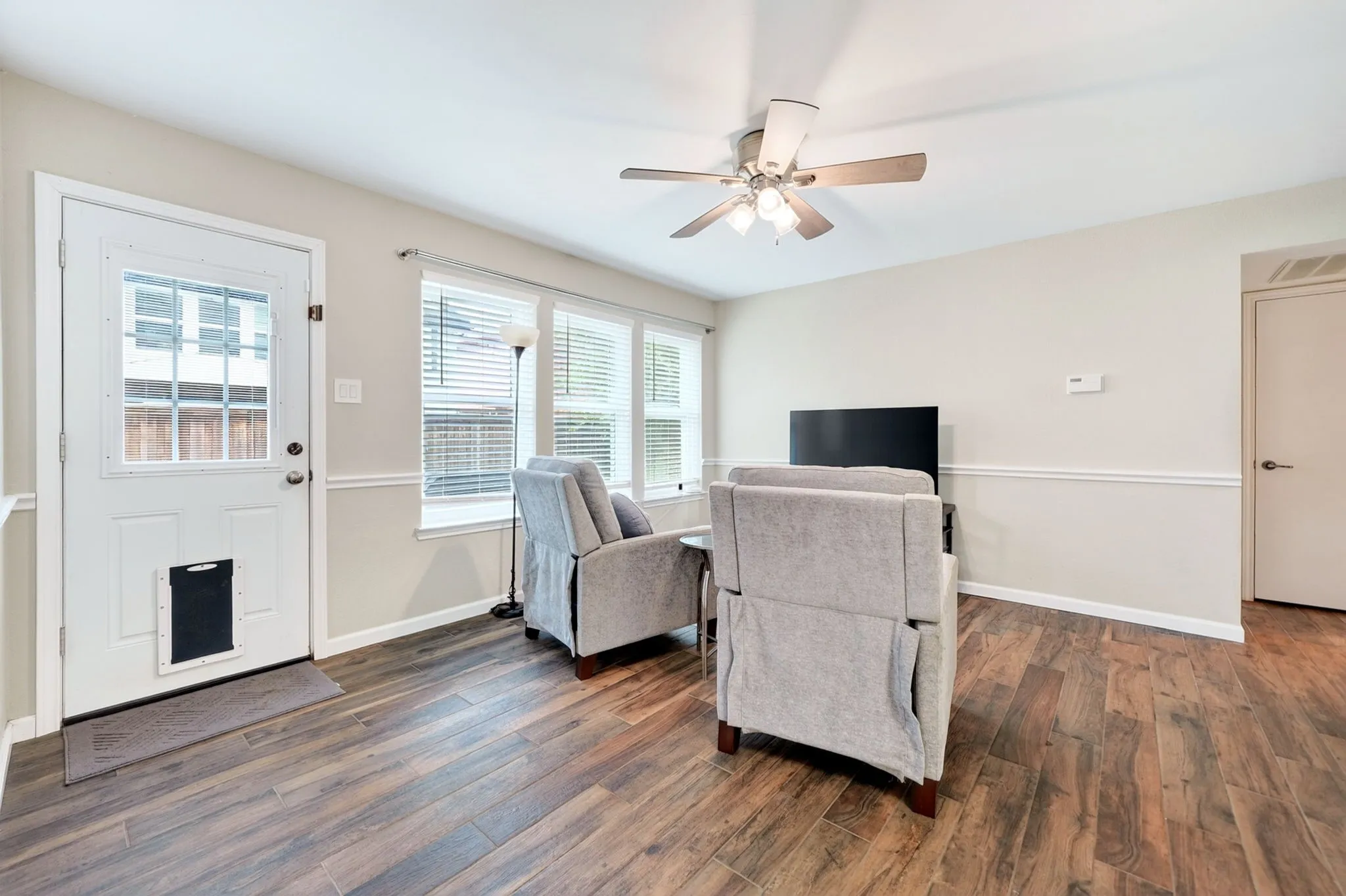 Wood-finish flooring throughout, light neutral paint, and white trim