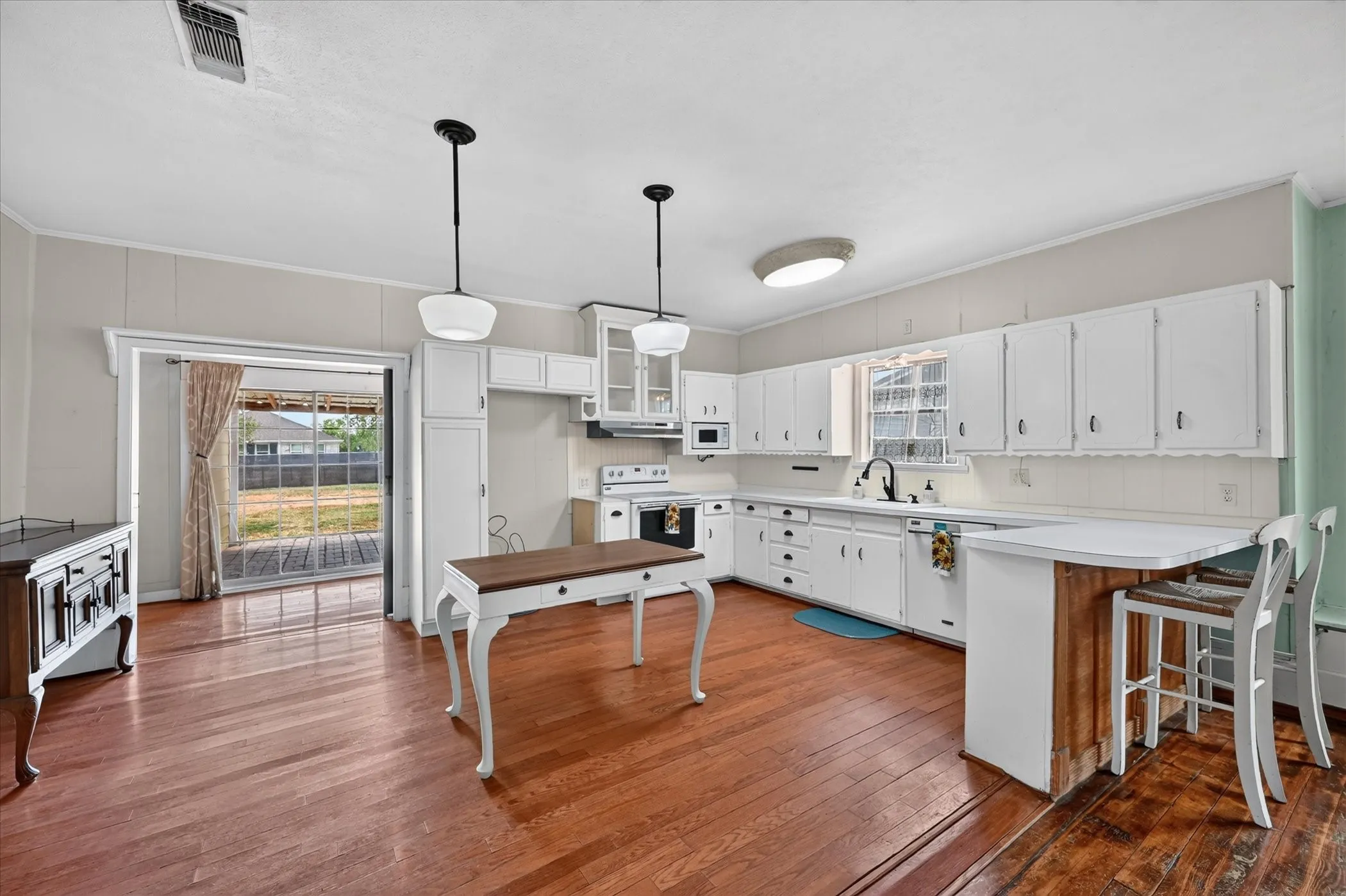 Kitchen featuring white cabinetry, counter space, and wood-finish flooring