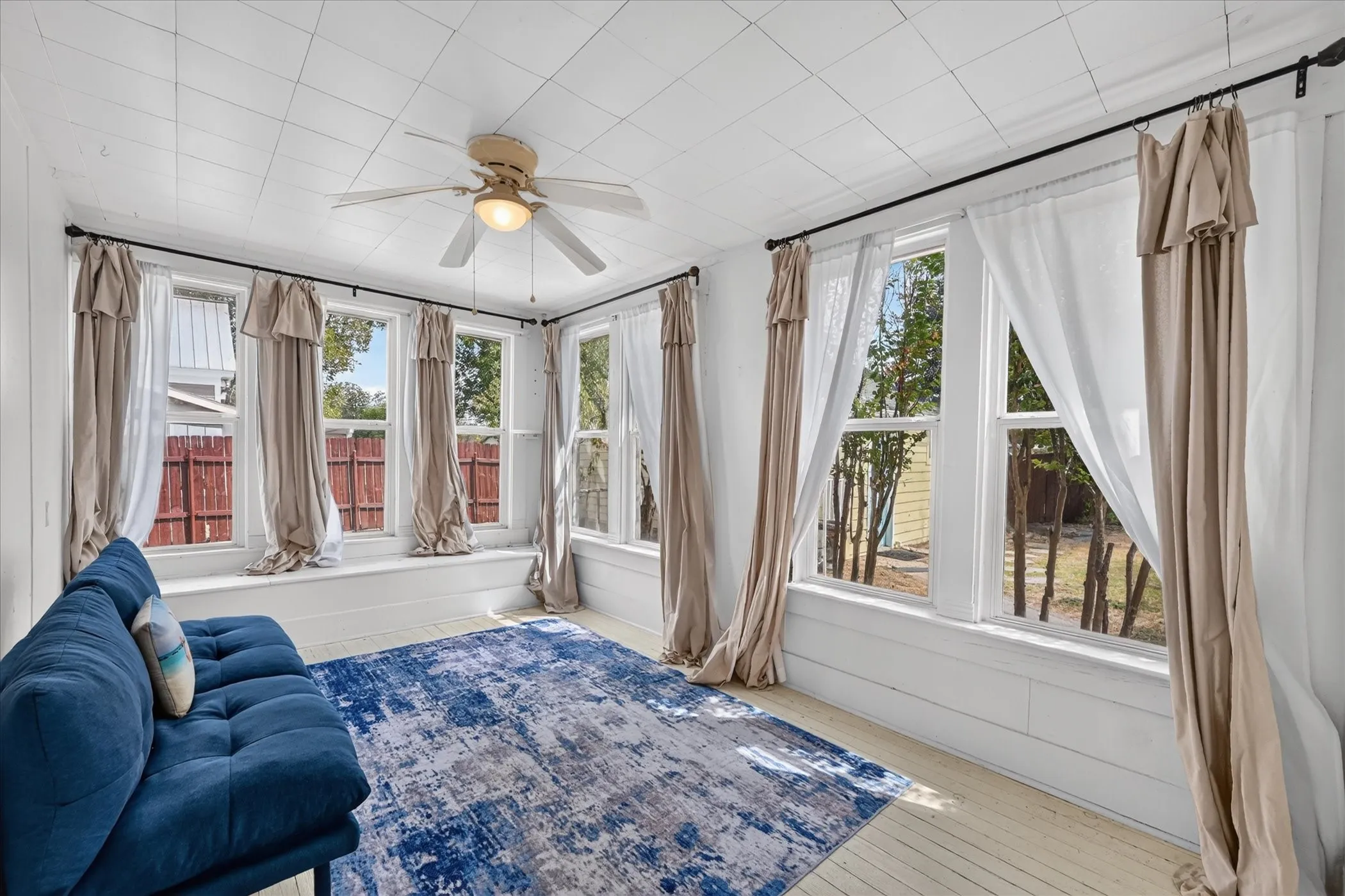 Bedroom featuring multiple windows, a ceiling fan, and light-toned flooring