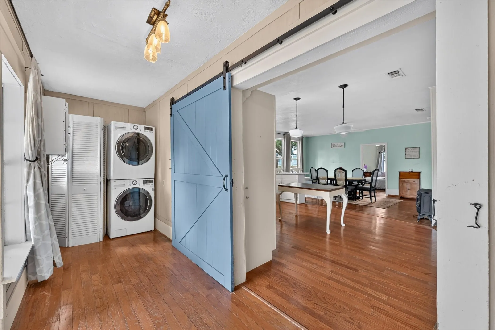 Wood-finish flooring throughout, featuring a functional laundry area with stacked​​‌​​​​‌​​‌‌​‌‌​​​‌‌​‌​‌​‌​​​‌​​ appliances