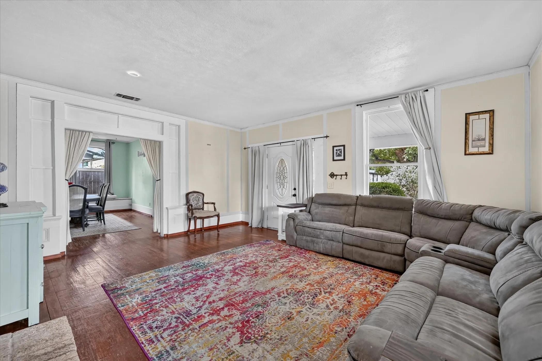 Hardwood flooring throughout, framed doorway with decorative trim, paneled interior door with frosted glass insert, and recessed lighting