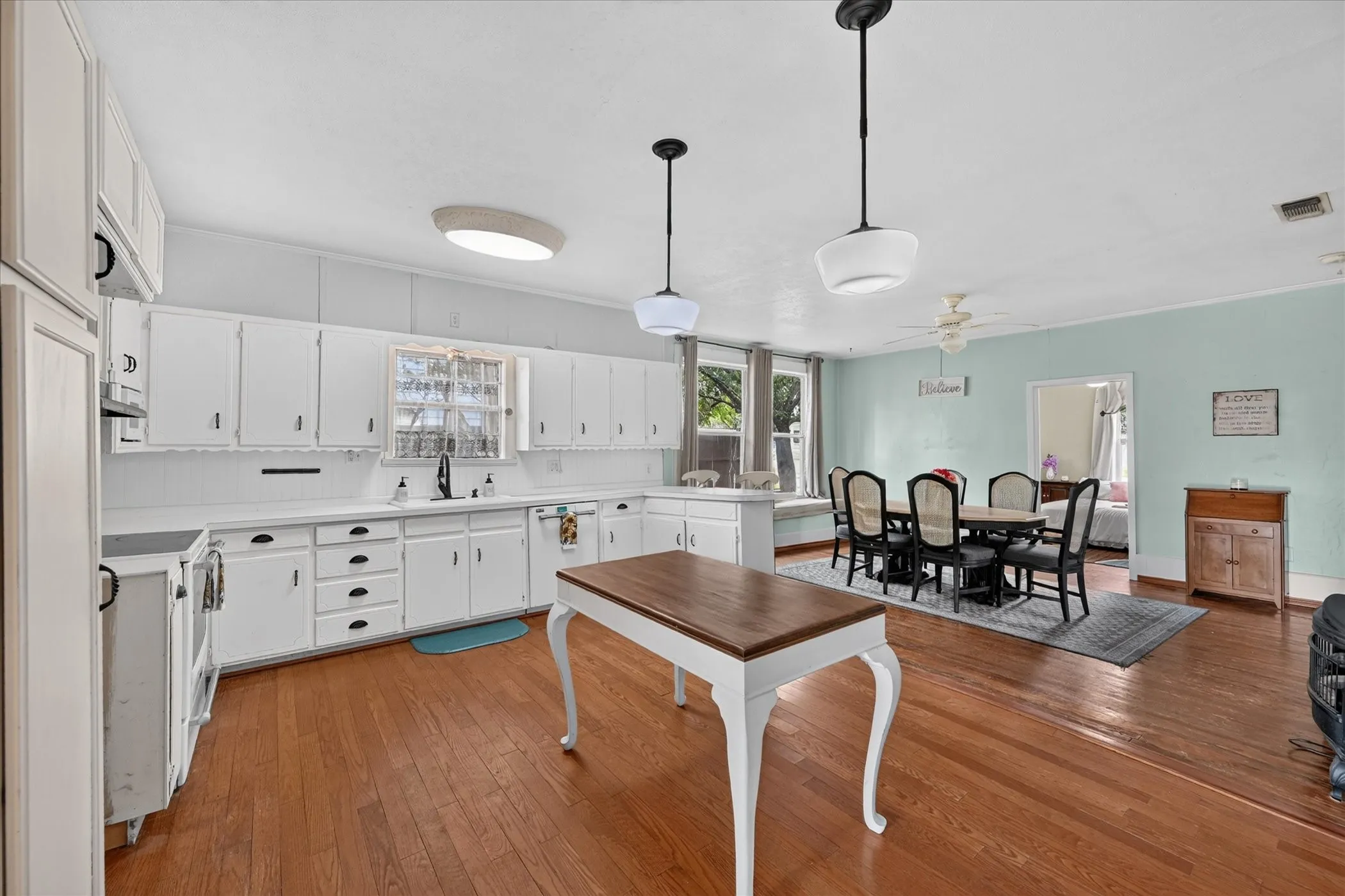 White cabinetry and countertops with hardwood flooring