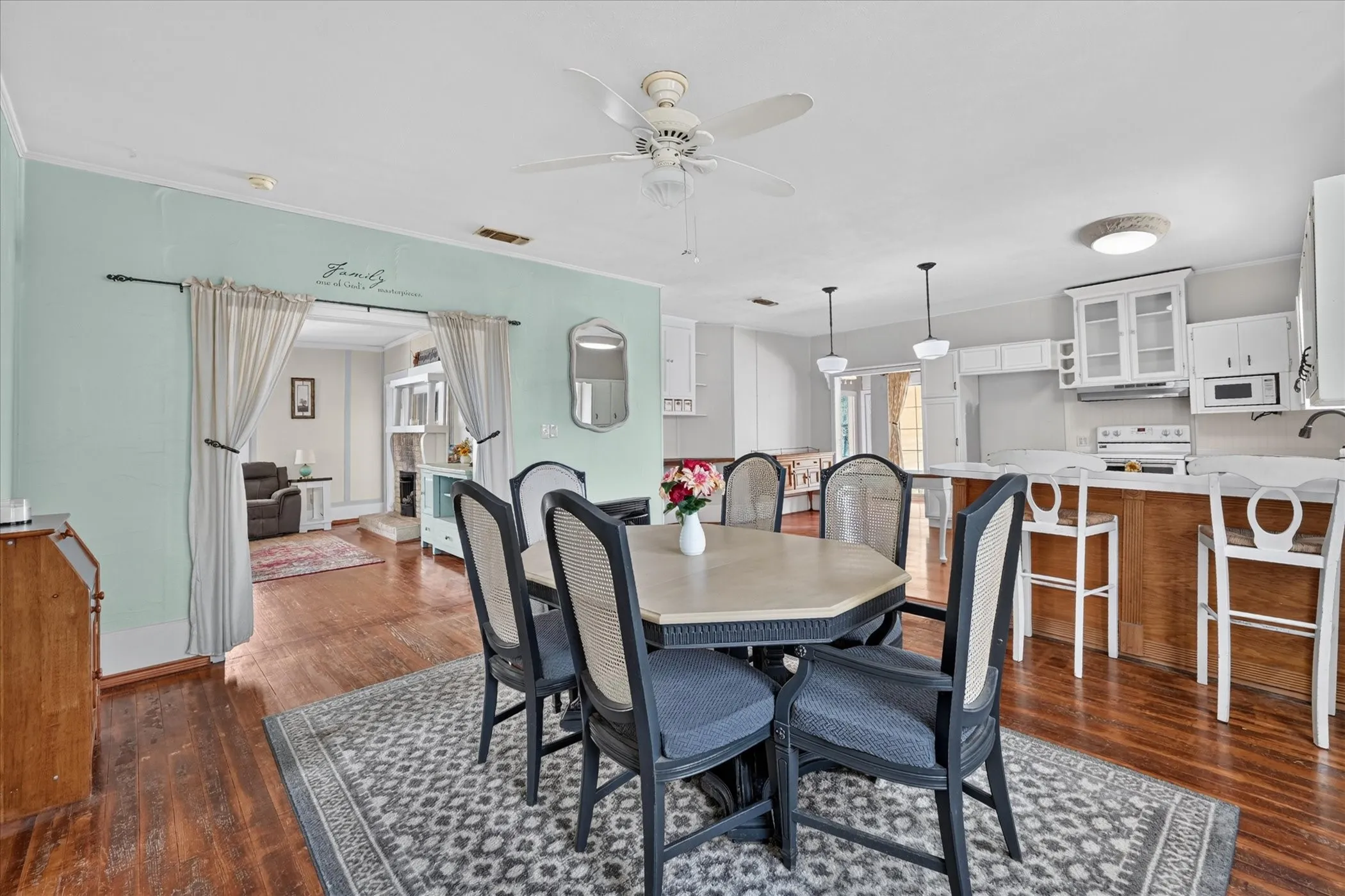 Wood-finish flooring extends throughout, complemented by a ceiling fan with integrated lighting