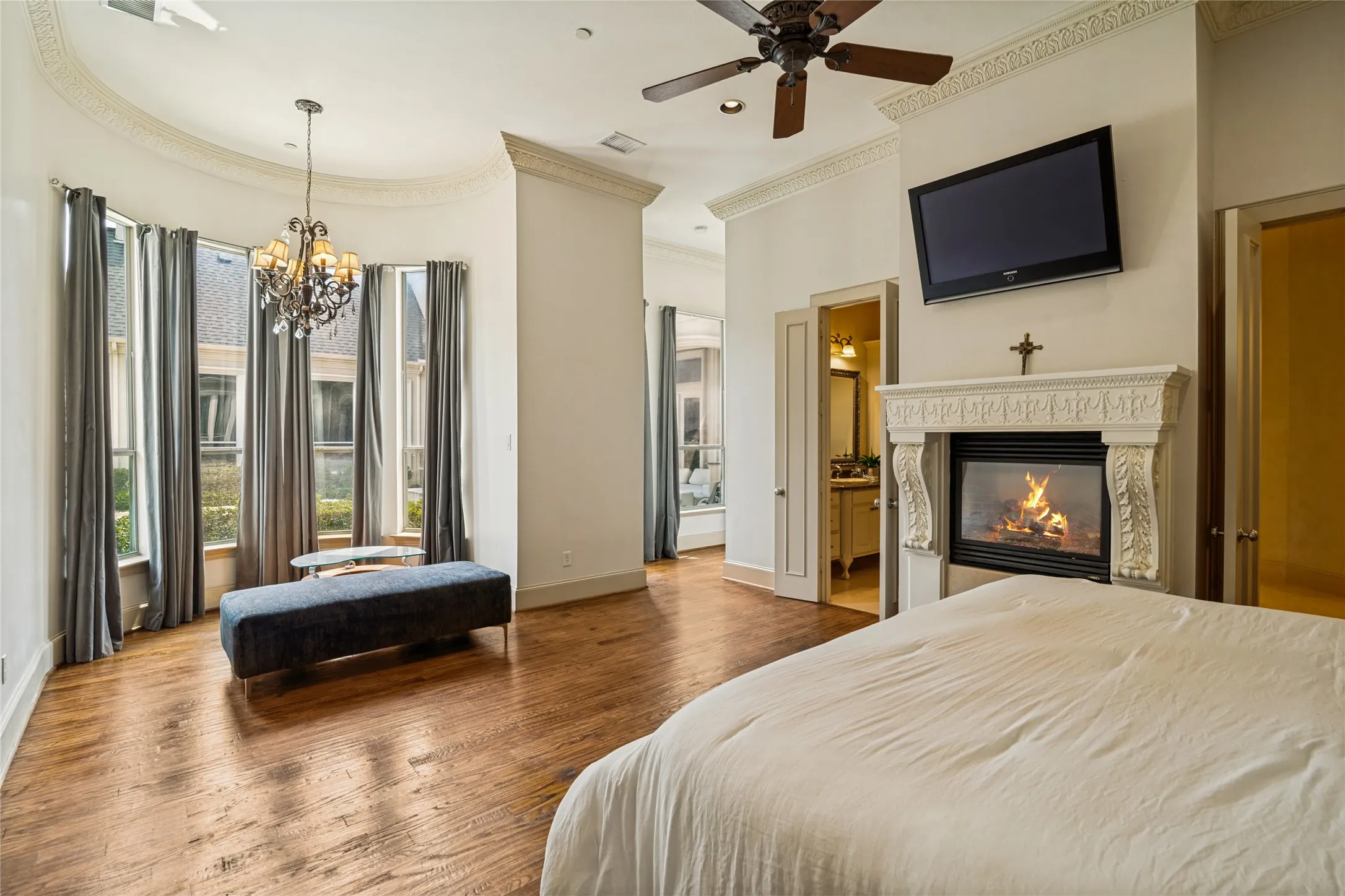 Hardwood flooring throughout, a decorative fireplace, and a ceiling fan