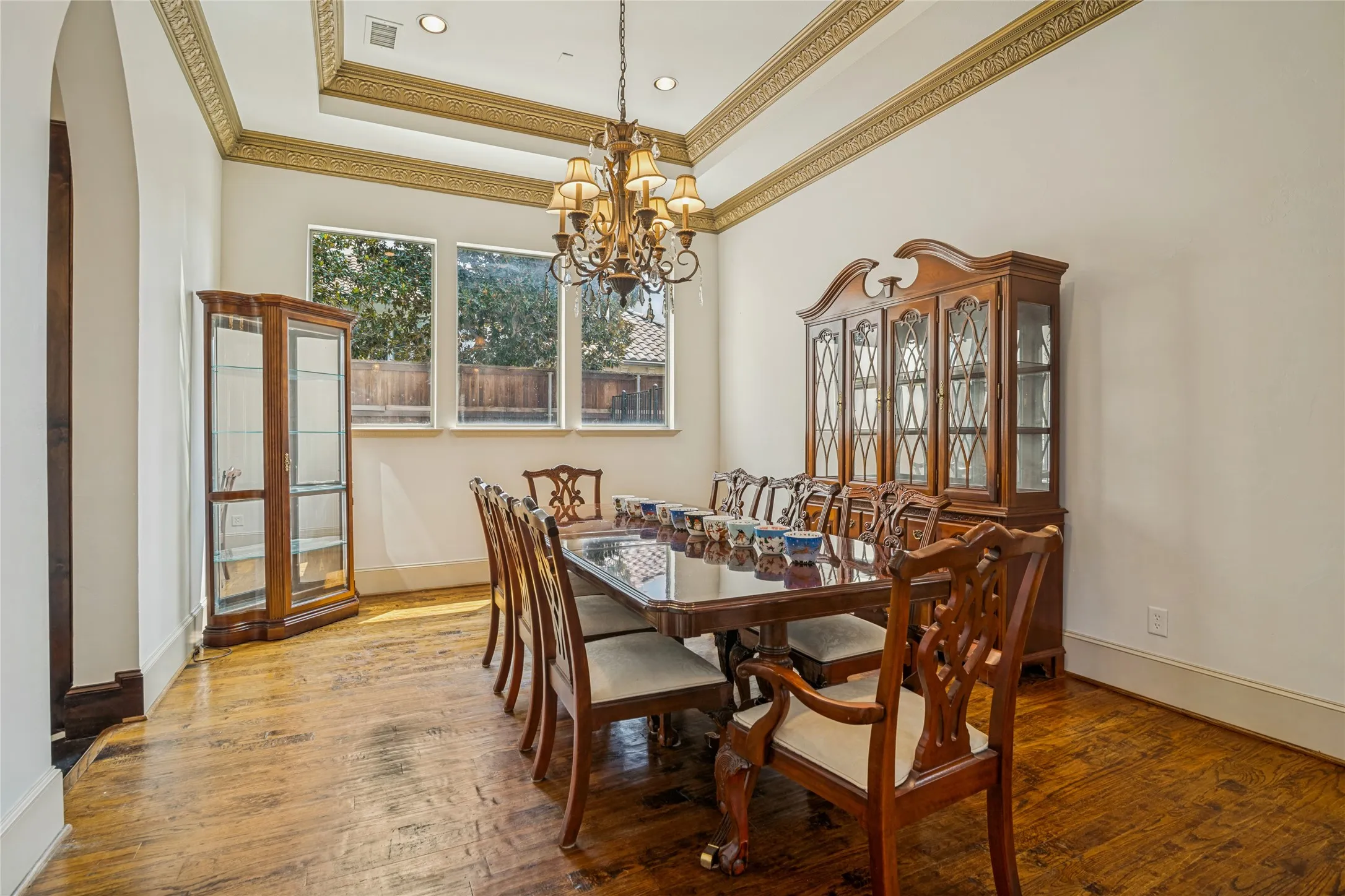 Coffered ceiling with decorative molding, recessed lighting, and a chandelier