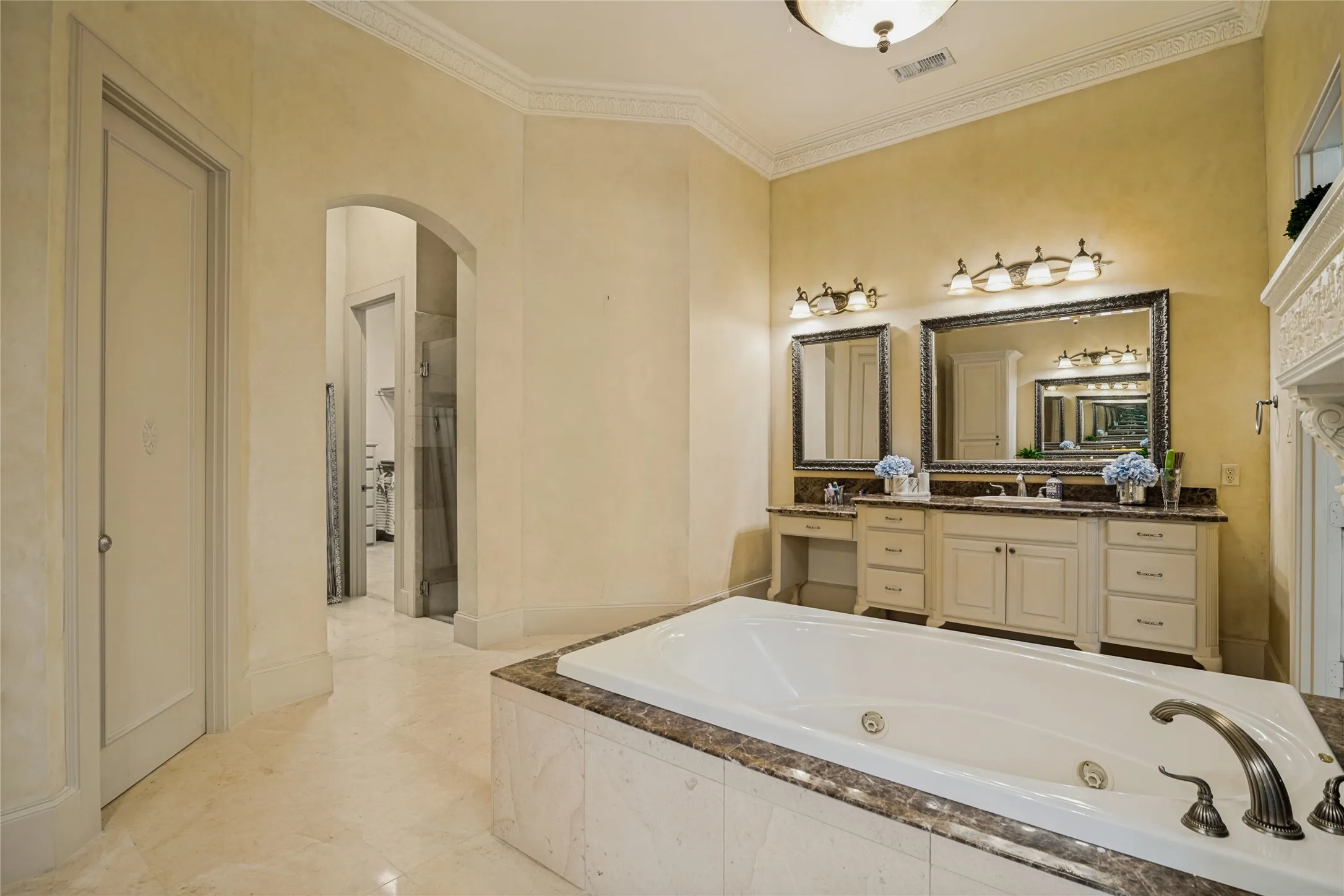 Soaking tub with a marbled surround and bronze-finish fixtures