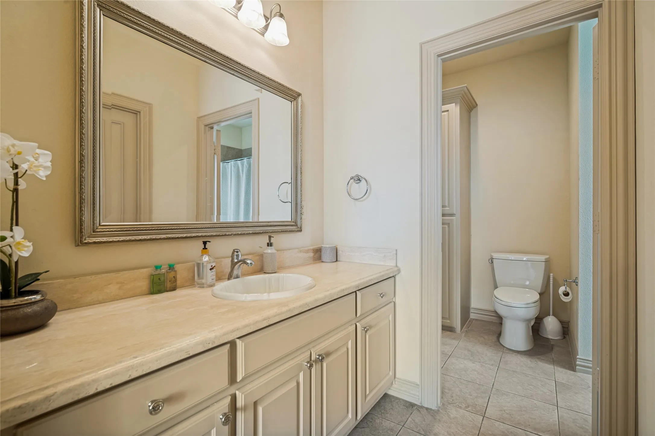 Vanity with an integrated sink, polished chrome faucet, and a stone-finish countertop