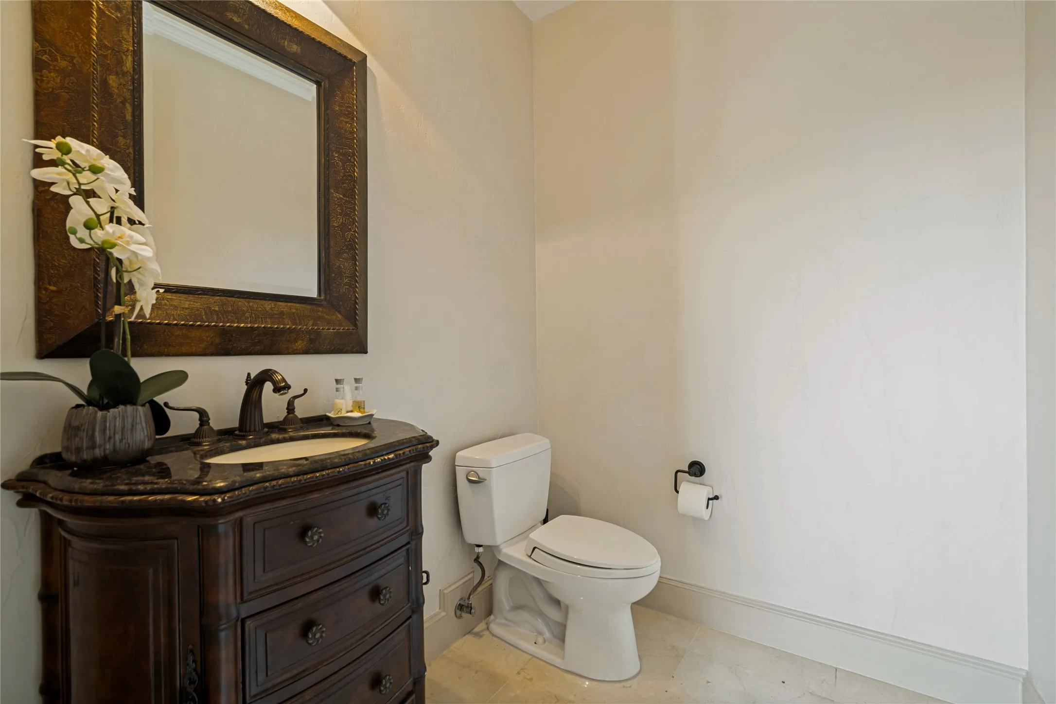 Ornate wood vanity with an integrated sink and bronze-finish faucet