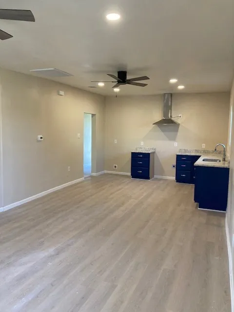 Wood-finish flooring throughout, complemented by recessed lighting and ceiling fans