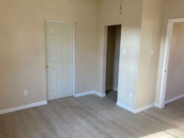 Light wood-finish flooring with white baseboards