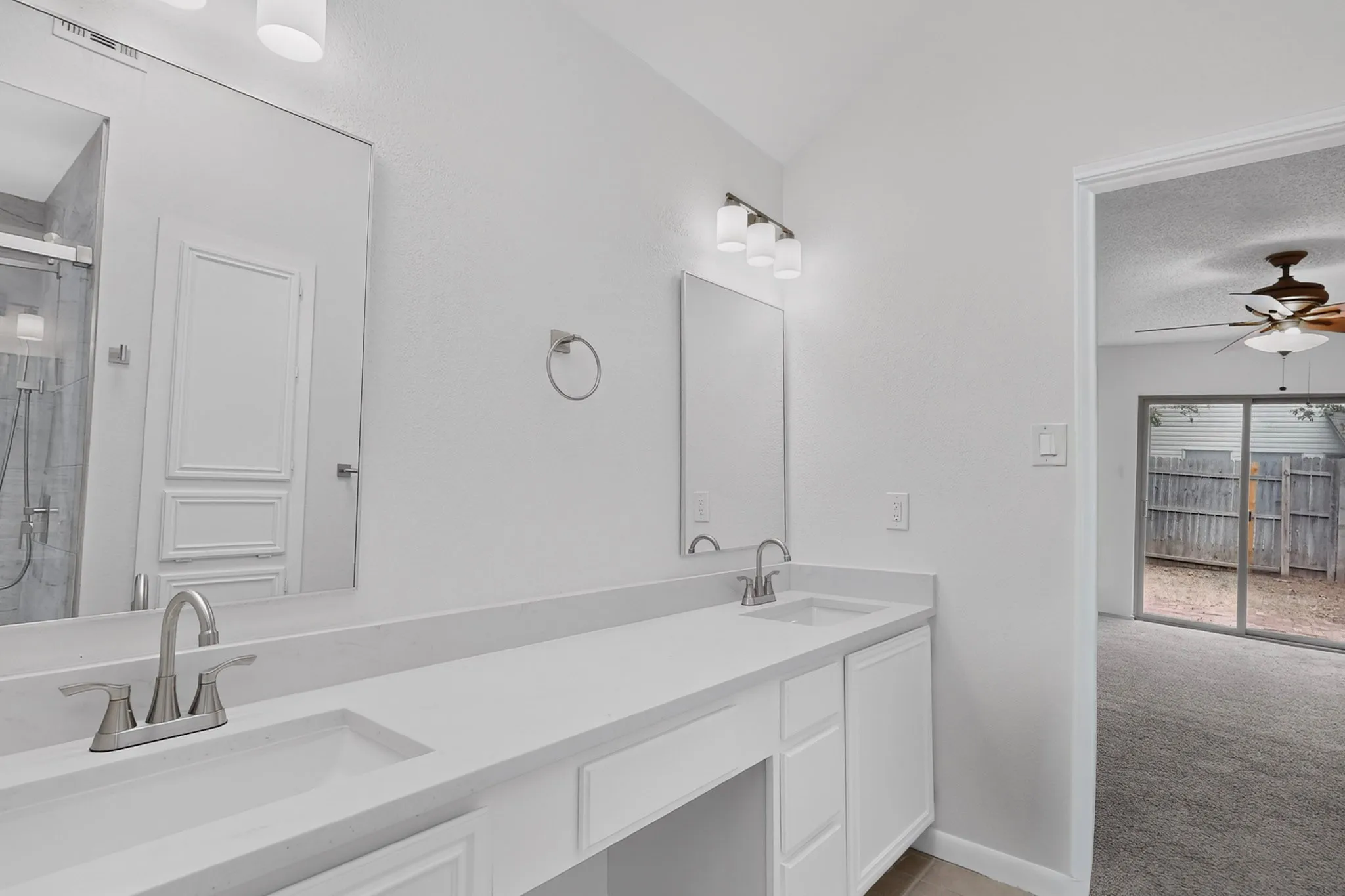 Dual vanity with undermount sinks, white cabinetry, and light-toned countertops
