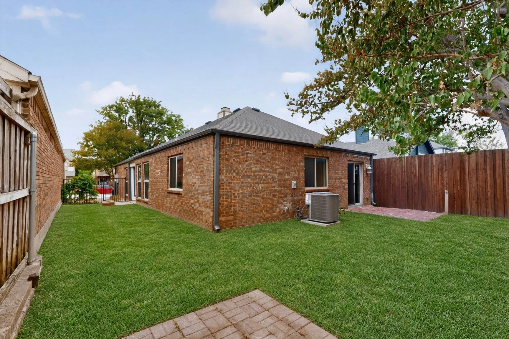 Brick exterior with multiple windows, a sliding glass door, and an outdoor HVAC unit - AI enhanced