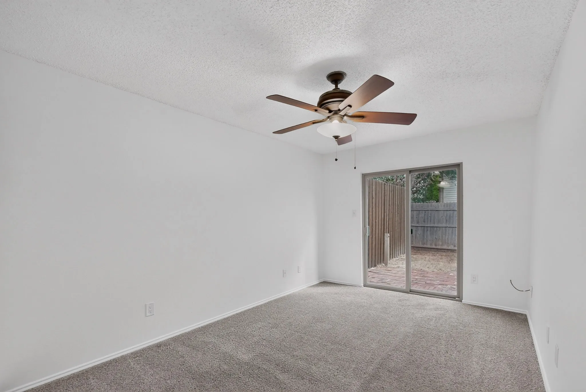 White painted walls with wall-to-wall carpeting and a ceiling fan