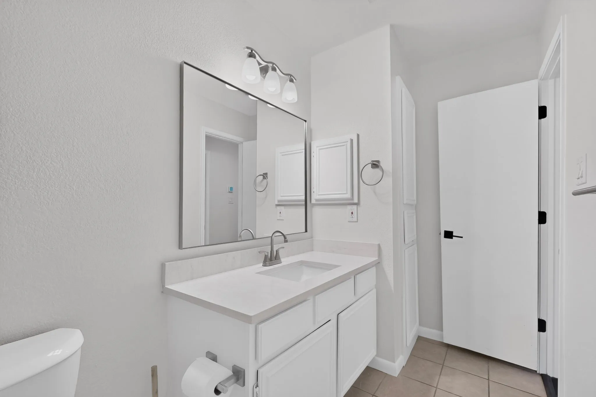 Bathroom vanity with a single basin sink, light-toned countertop, and integrated storage cabinetry