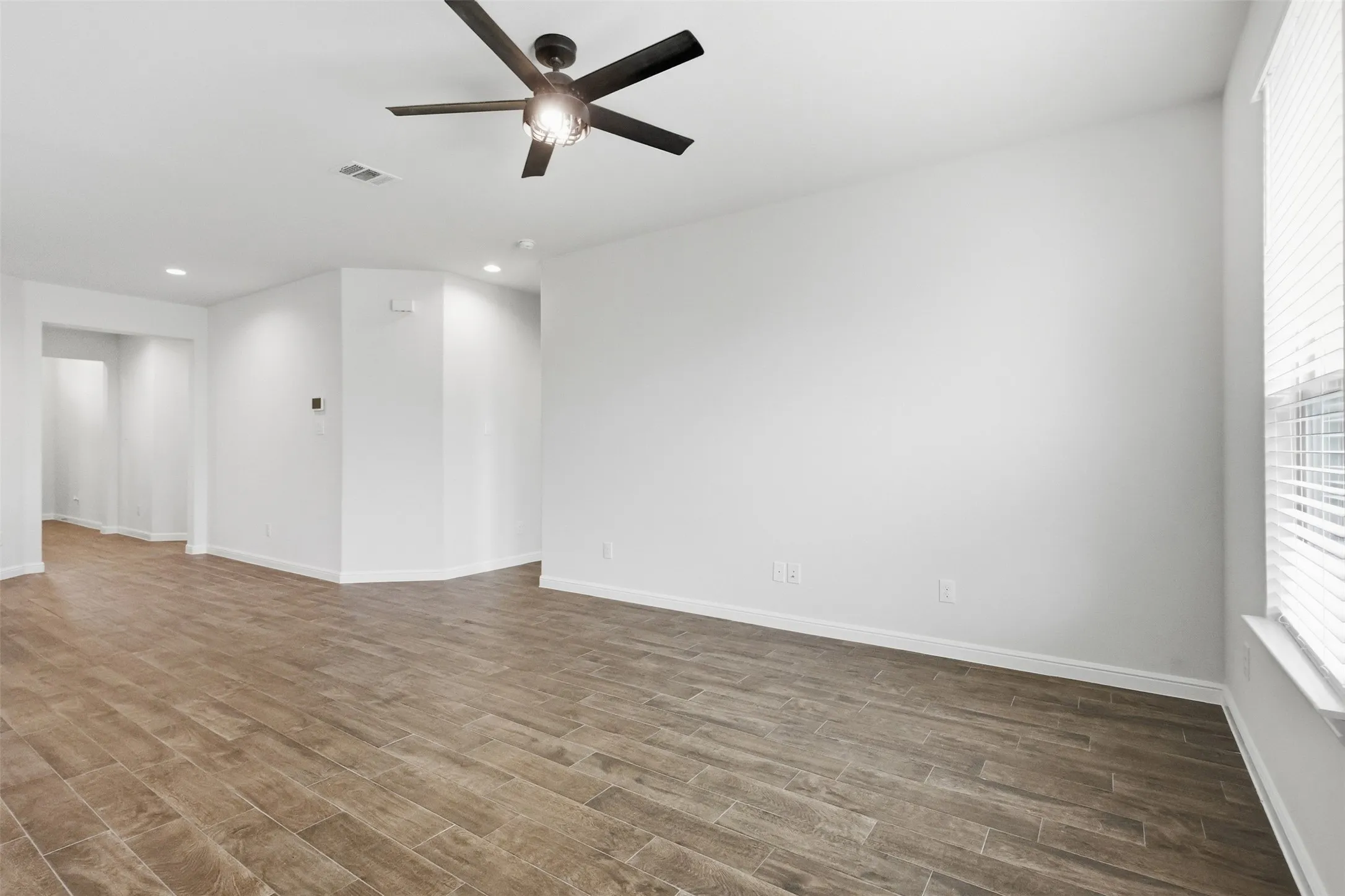 Tile flooring, white walls, recessed ceiling lights, and a ceiling fan with integrated lighting
