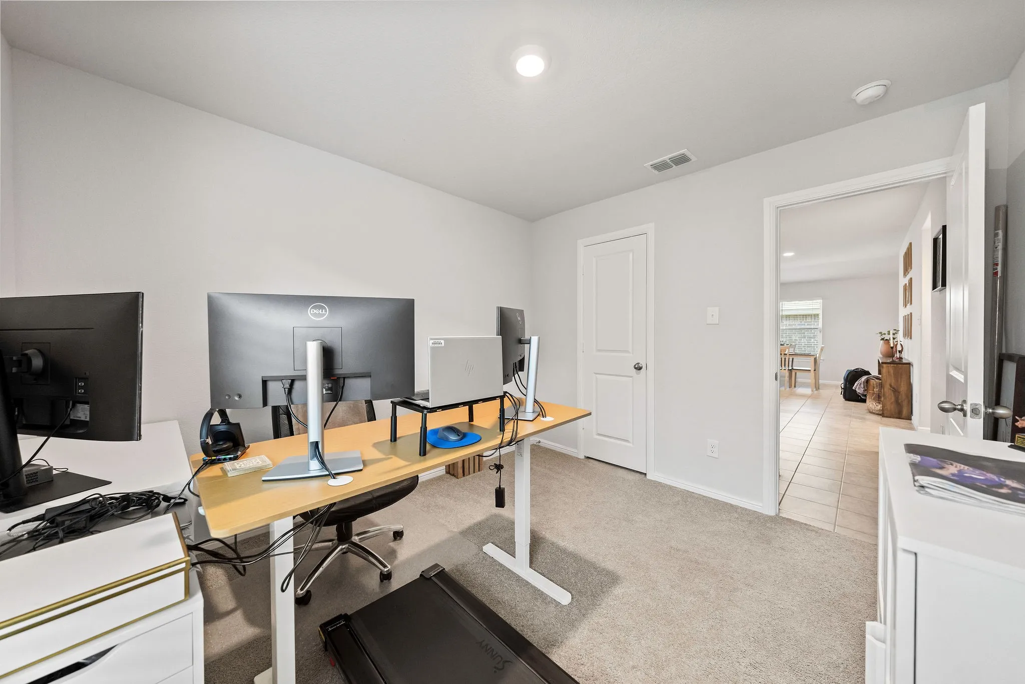 Office with light carpet and recessed lighting