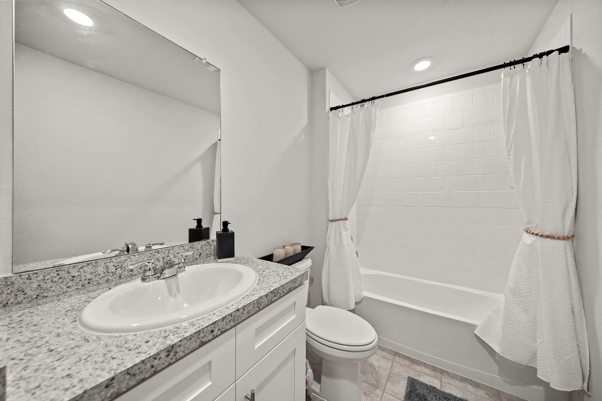 Bathroom with vanity, shower / tub combo, and recessed lighting