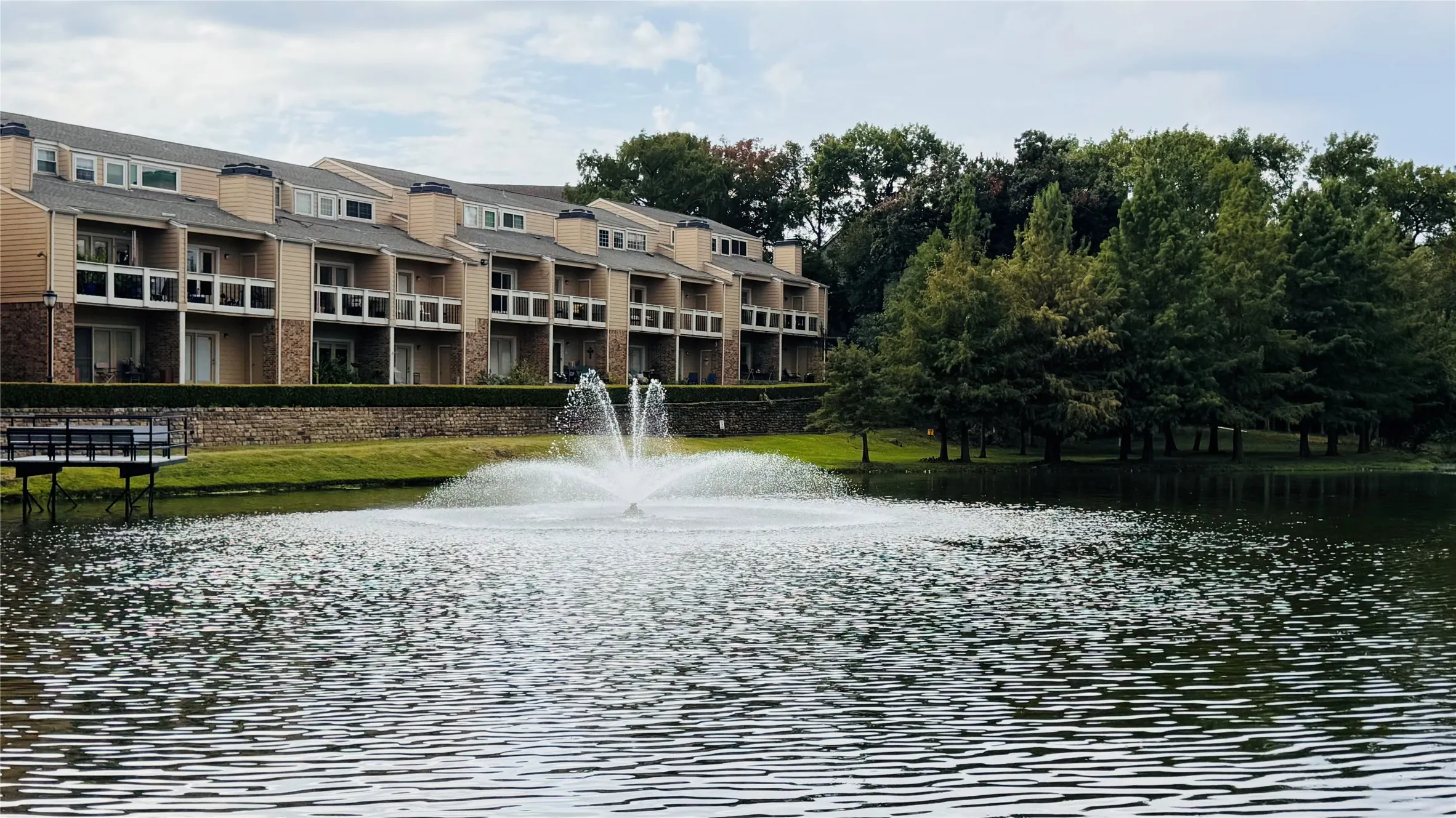 Water feature with fountain, surrounded by mature trees