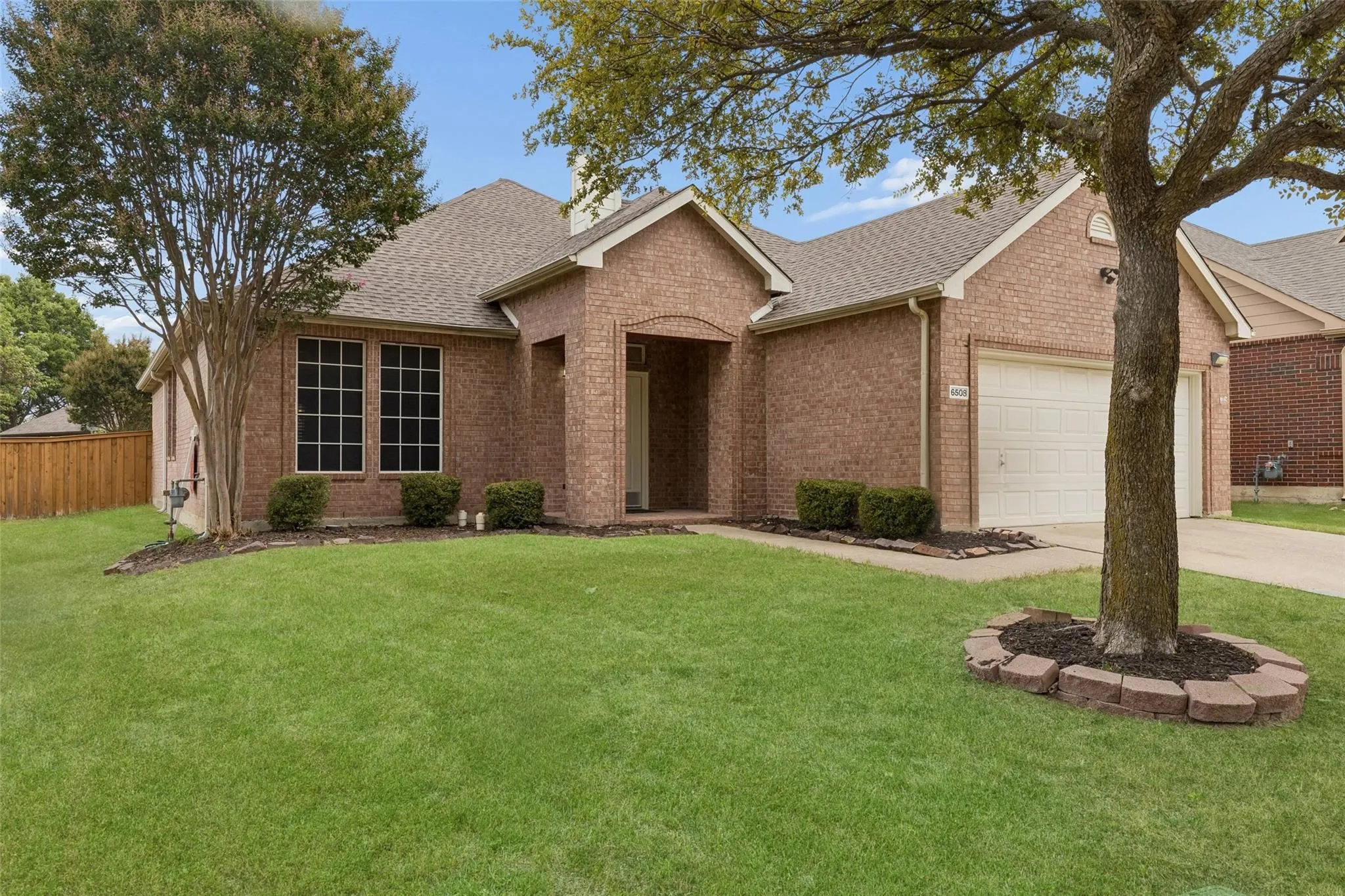 Brick exterior with an attached garage, covered entry, and large front windows