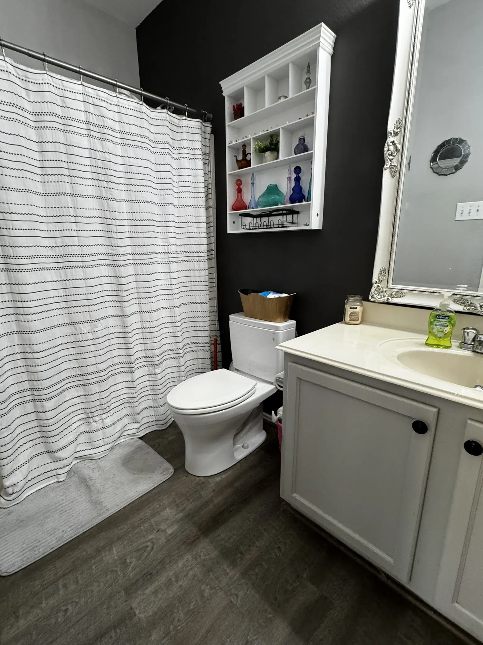 Wood-finish flooring with a vanity featuring a built-in sink and white cabinetry