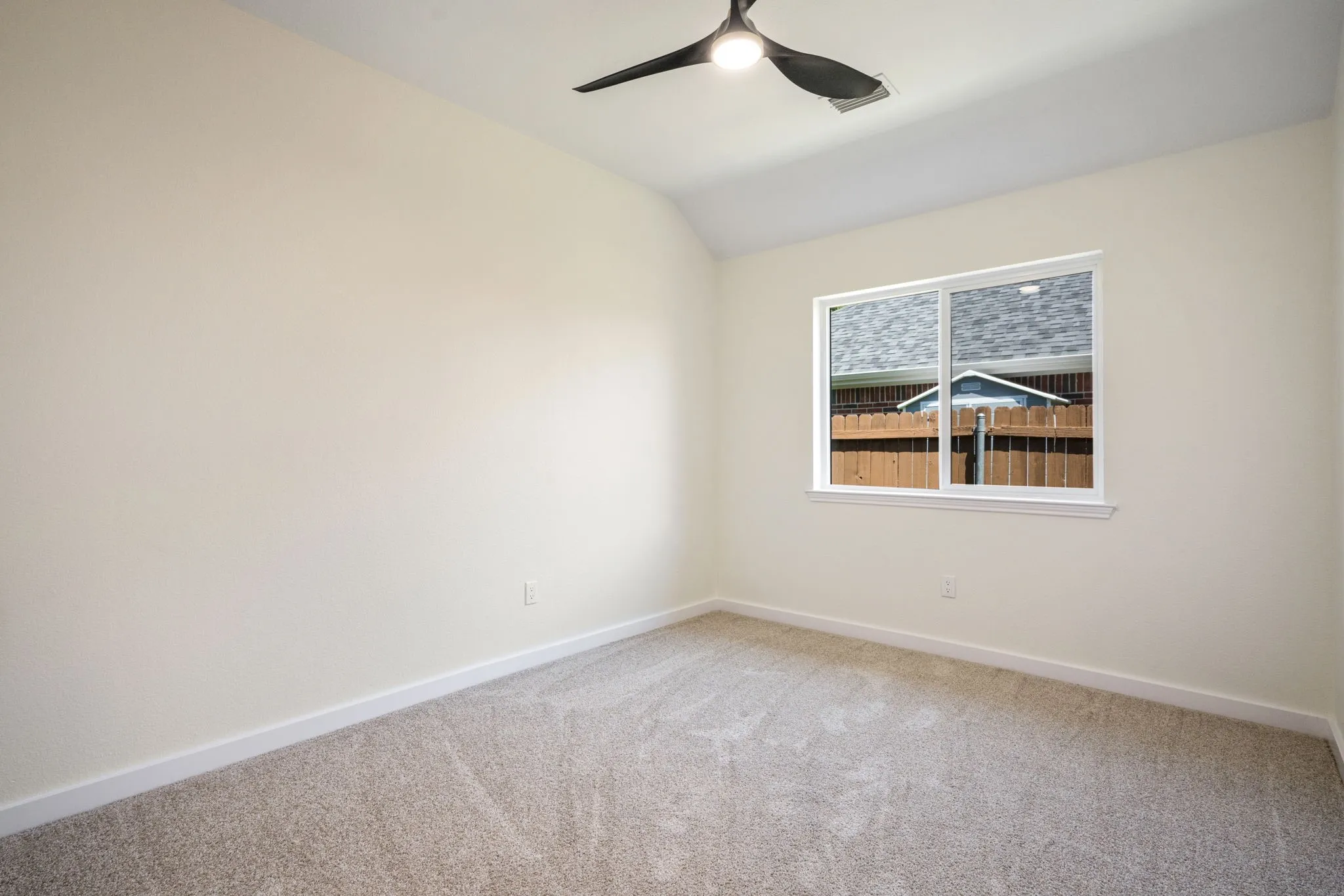 Neutral-toned walls with a white-framed window, light-colored carpeting, and a ceiling-mounted fixture
