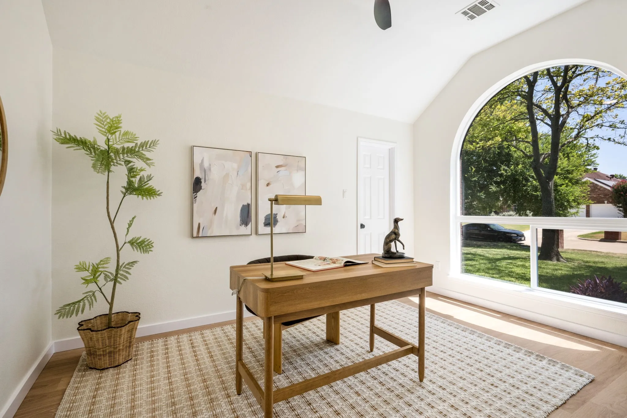 4th Bedroom converted to Office, Arched window with ample natural light, vaulted ceiling, wood-finish flooring, and a white paneled door