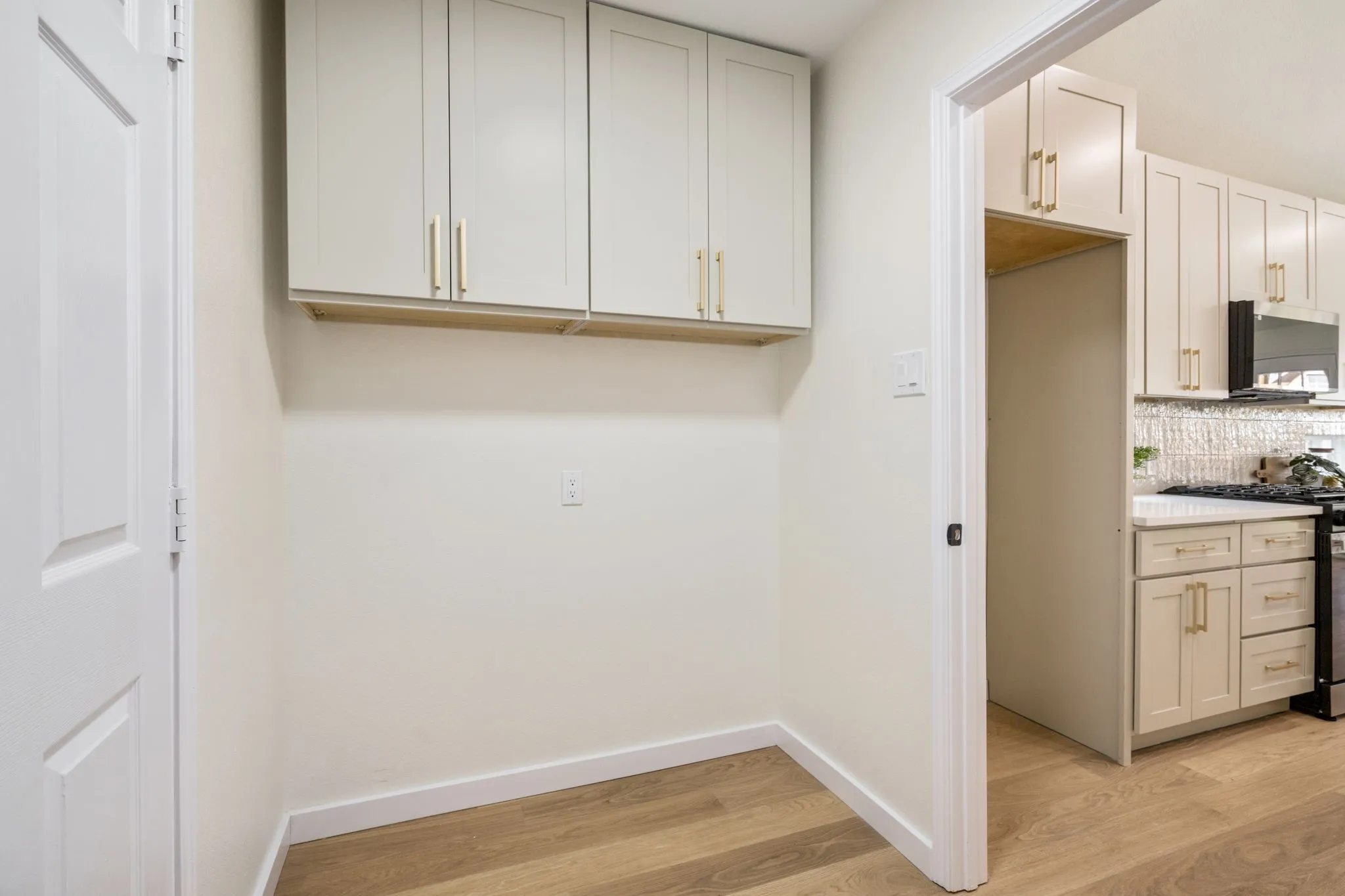 Light-toned wall cabinets with gold-tone hardware